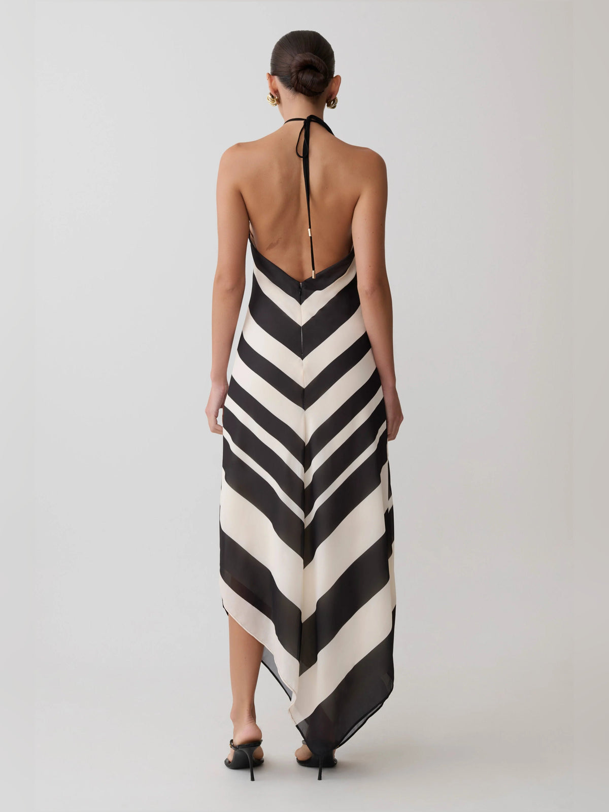 Back view of satin halter midi formal dress with black-and-white chevron zigzag, open-back tie.