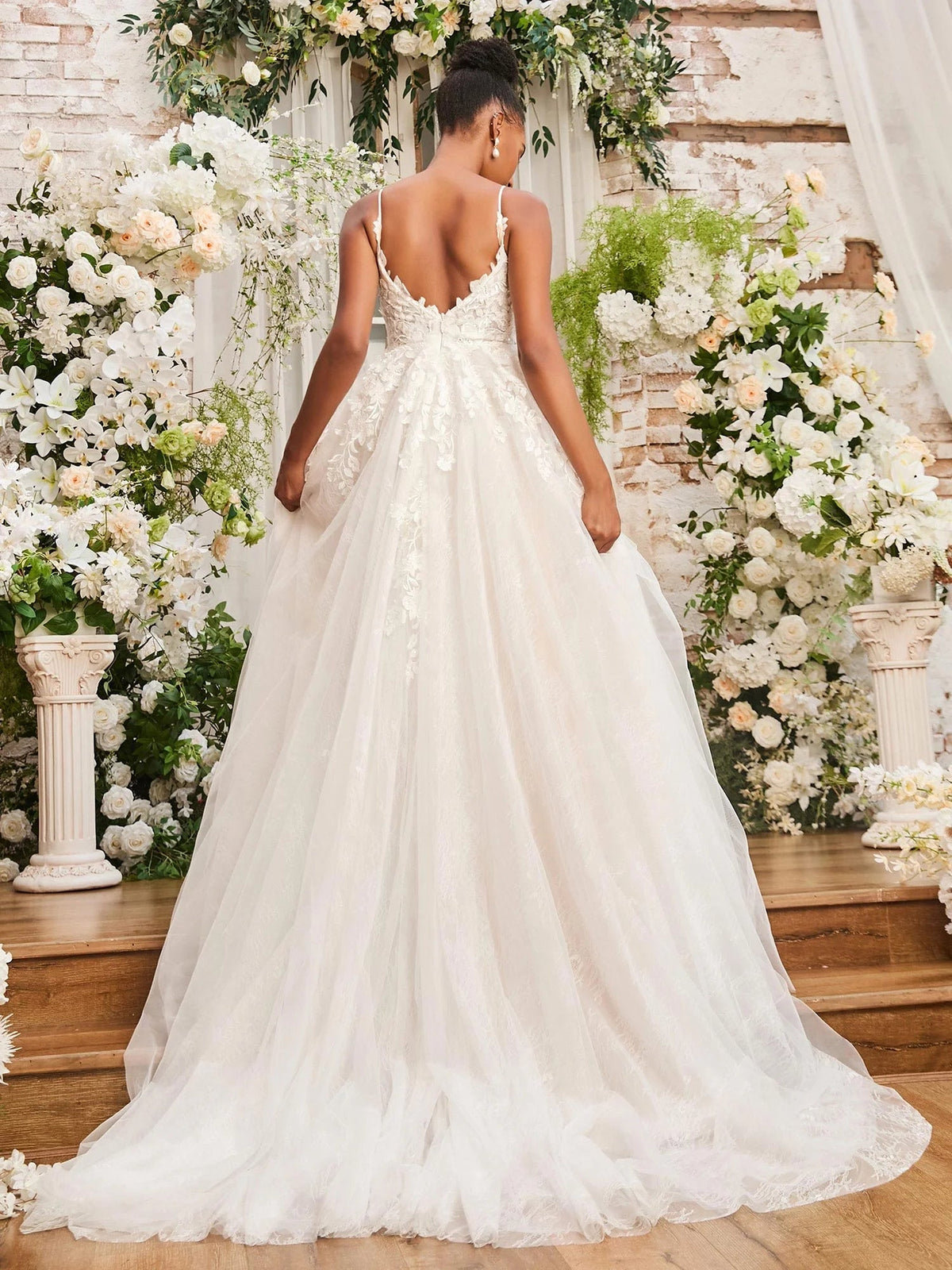 Ivory A-line wedding dress viewed from back, layered tulle skirt and lace detailing