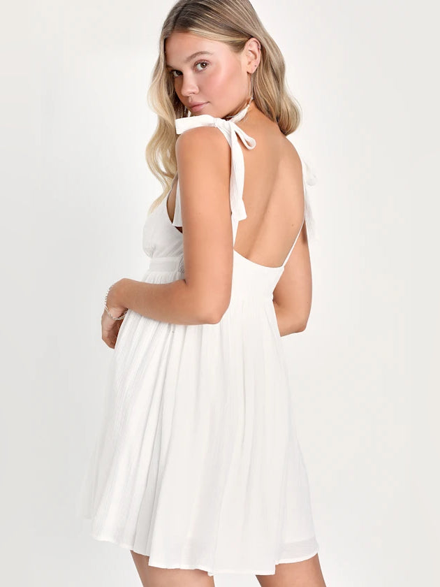 White mini homecoming dress with V-neck and tie straps, open back detail