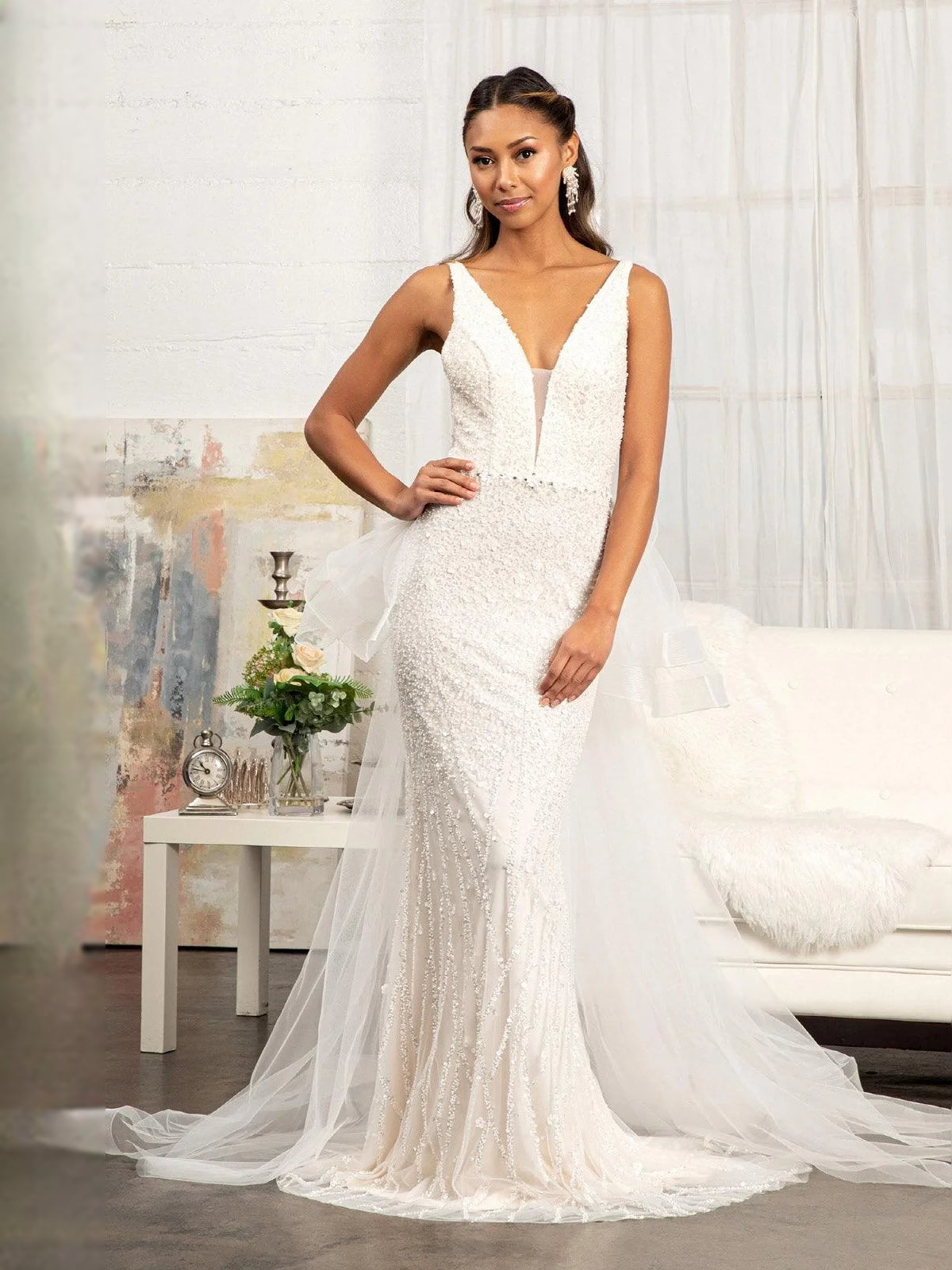 Ivory sleeveless V-neck mermaid wedding dress with textured bodice and flowing tulle train