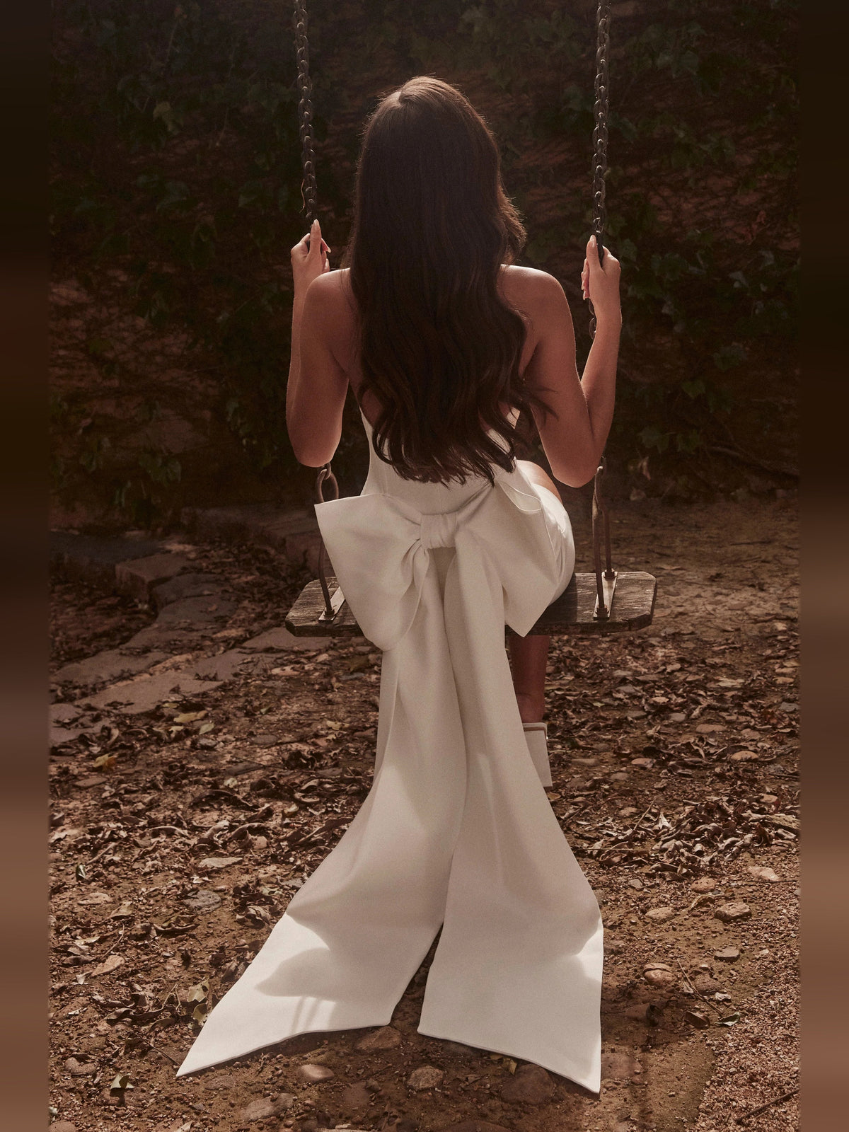 White mini dress with strapless sweetheart neckline and long bow-back tail