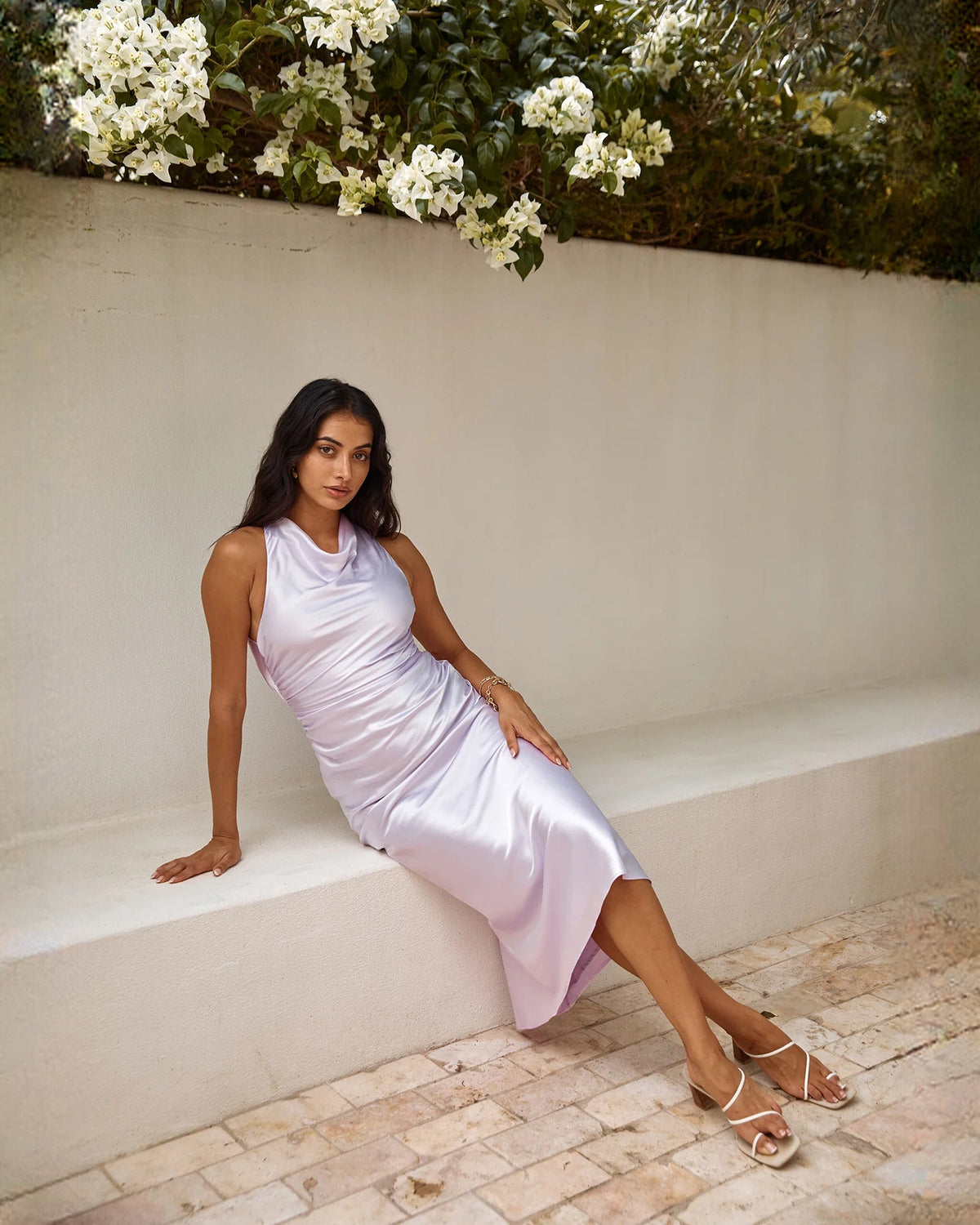 Lilac satin sleeveless A-line dress posed on steps, side slit visible