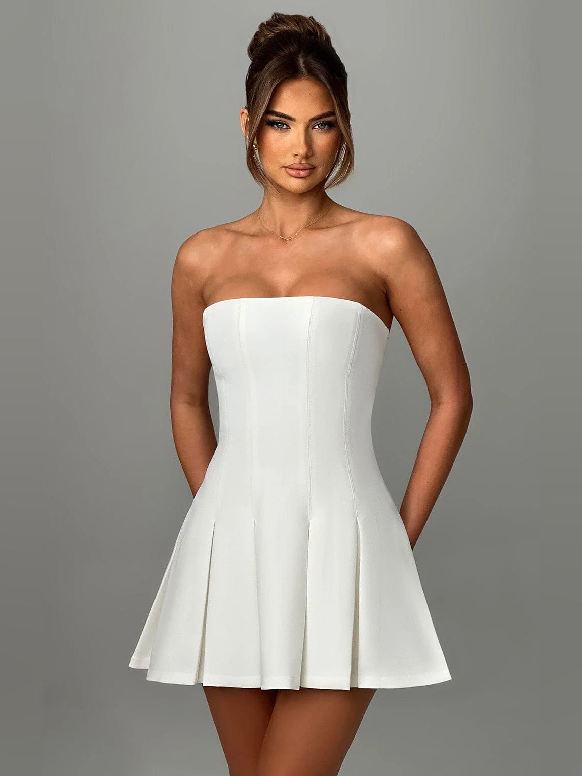Ivory strapless mini homecoming dress with fitted bust and pleated A-line skirt
