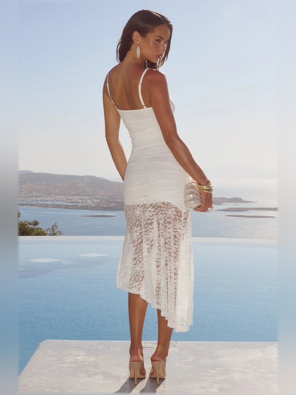 White midi formal dress with spaghetti straps, lace panel asymmetrical hem, back view
