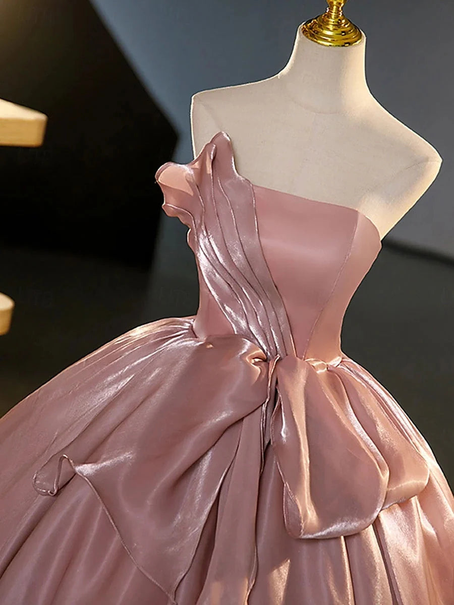 Blush pink satin strapless corset bodice with layered bow detail on draped skirt