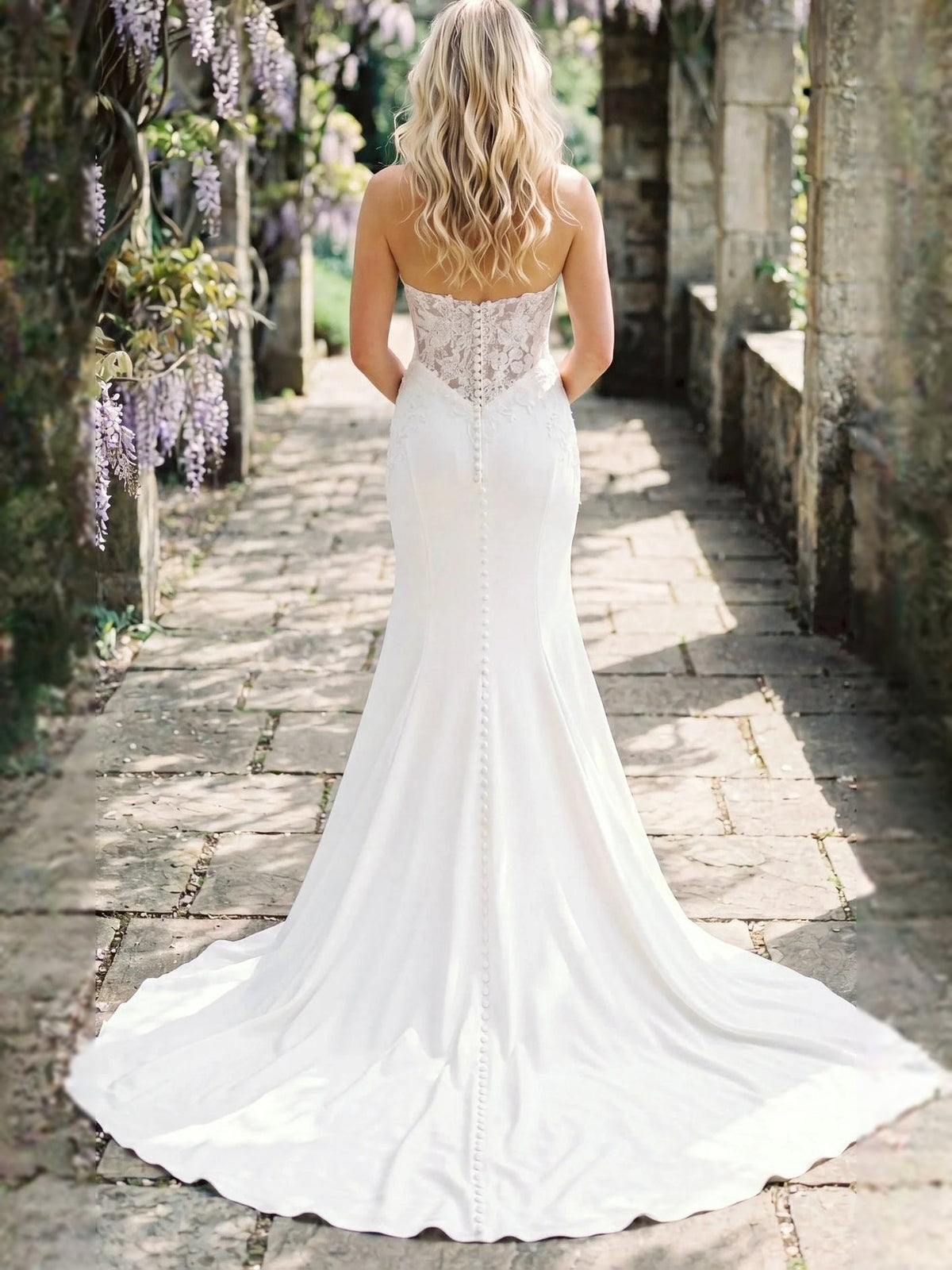 Ivory back view of strapless lace corset wedding dress with long mermaid train