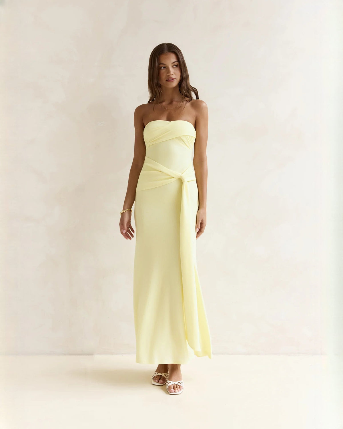 Light yellow strapless satin A-line maxi dress with sweetheart neckline and draped sash