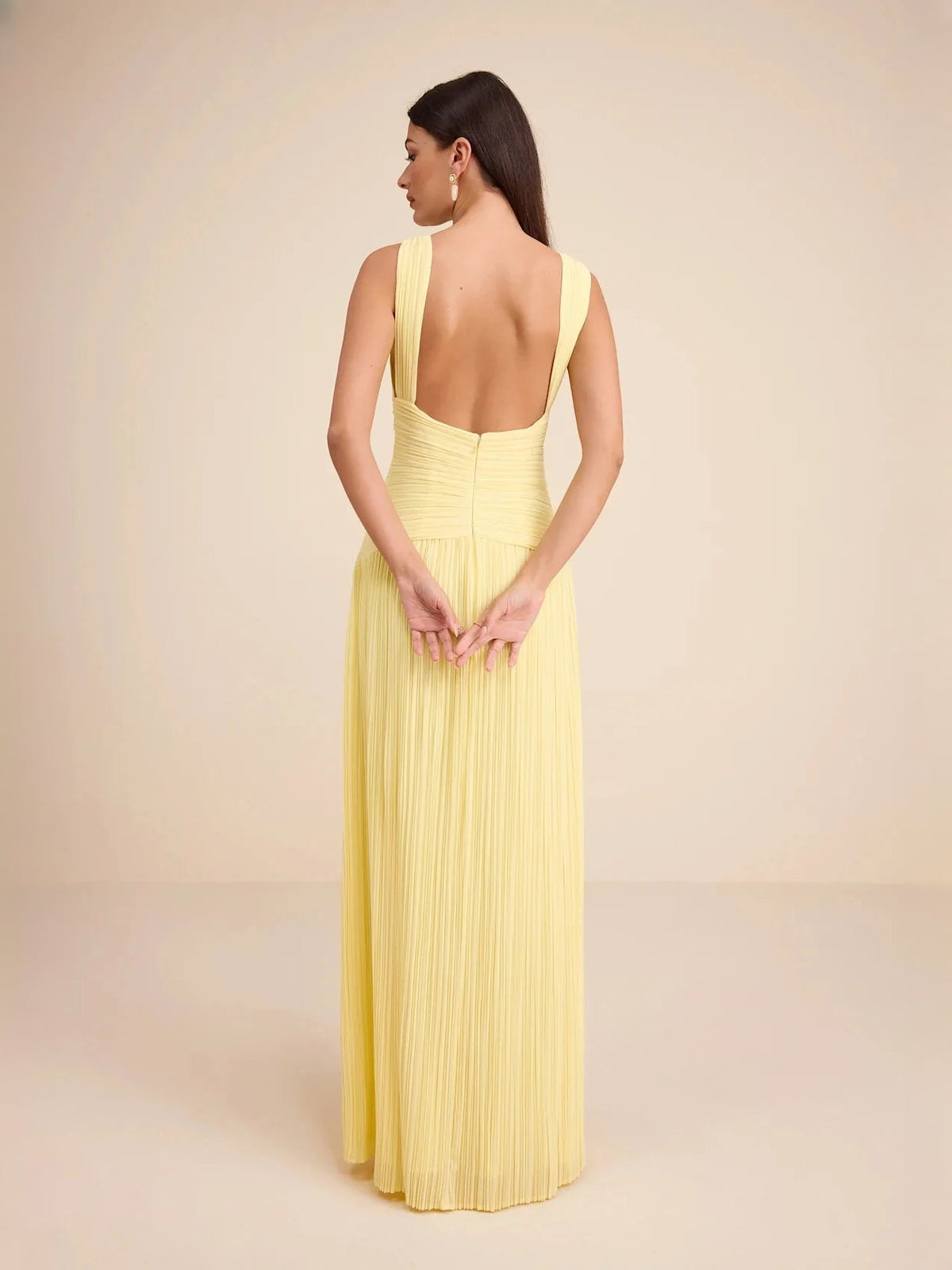 Back view of light yellow V-neck tiered maxi dress with pleated chiffon skirt