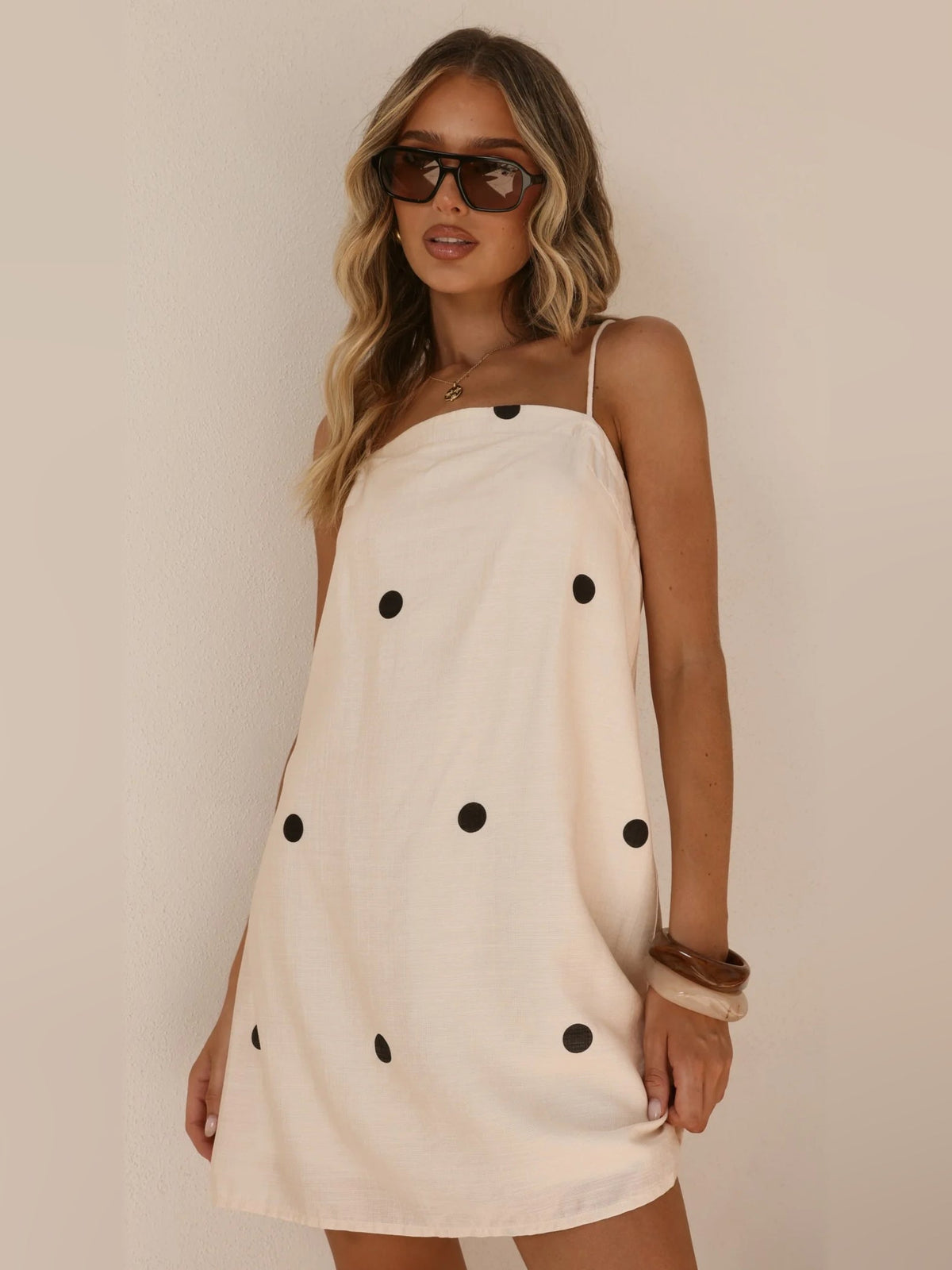 Cream mini dress with black polka dots, spaghetti straps, sleeveless square neck