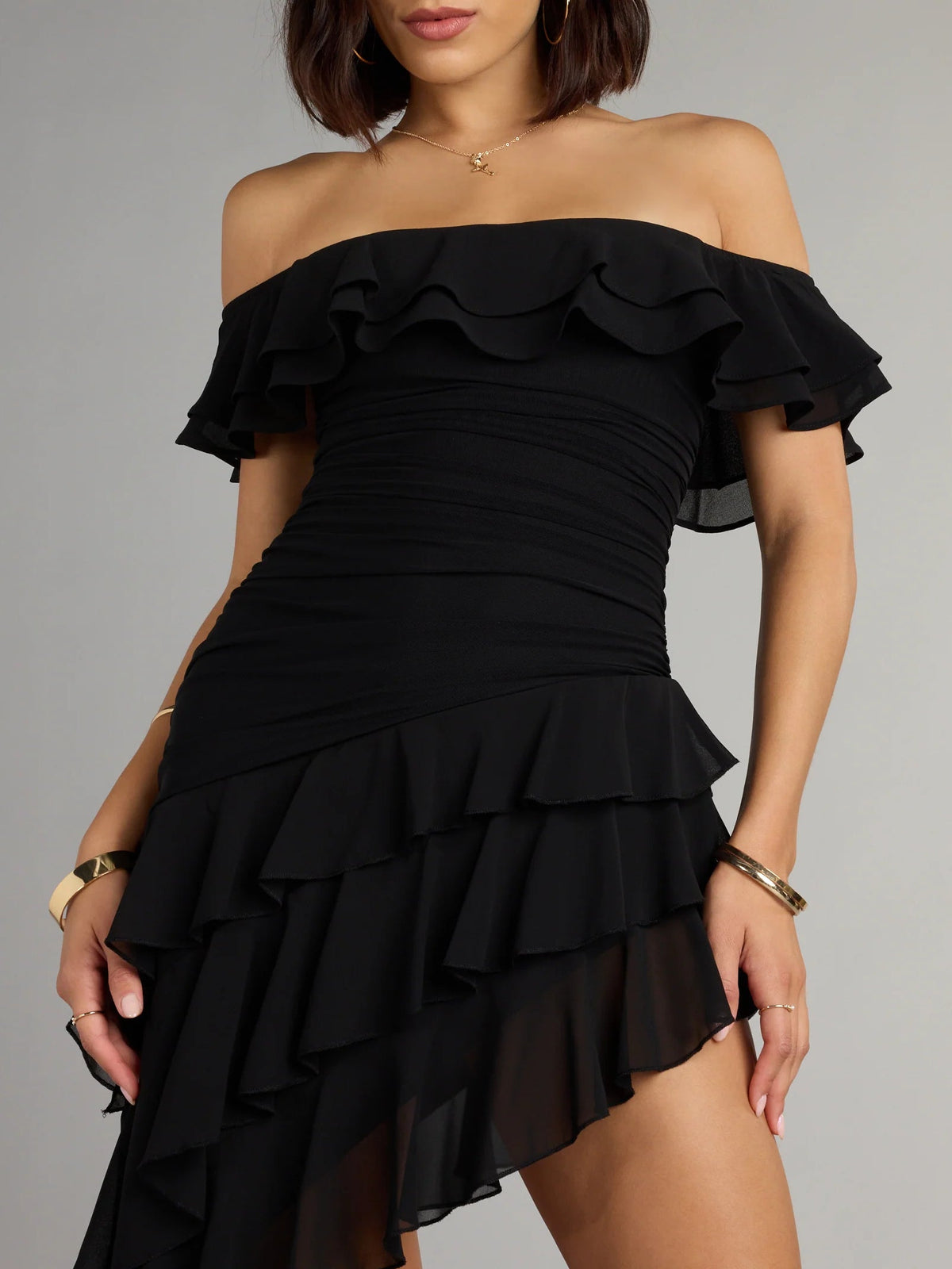 Black off-shoulder ruffle bodice with layered mini skirt, close-up