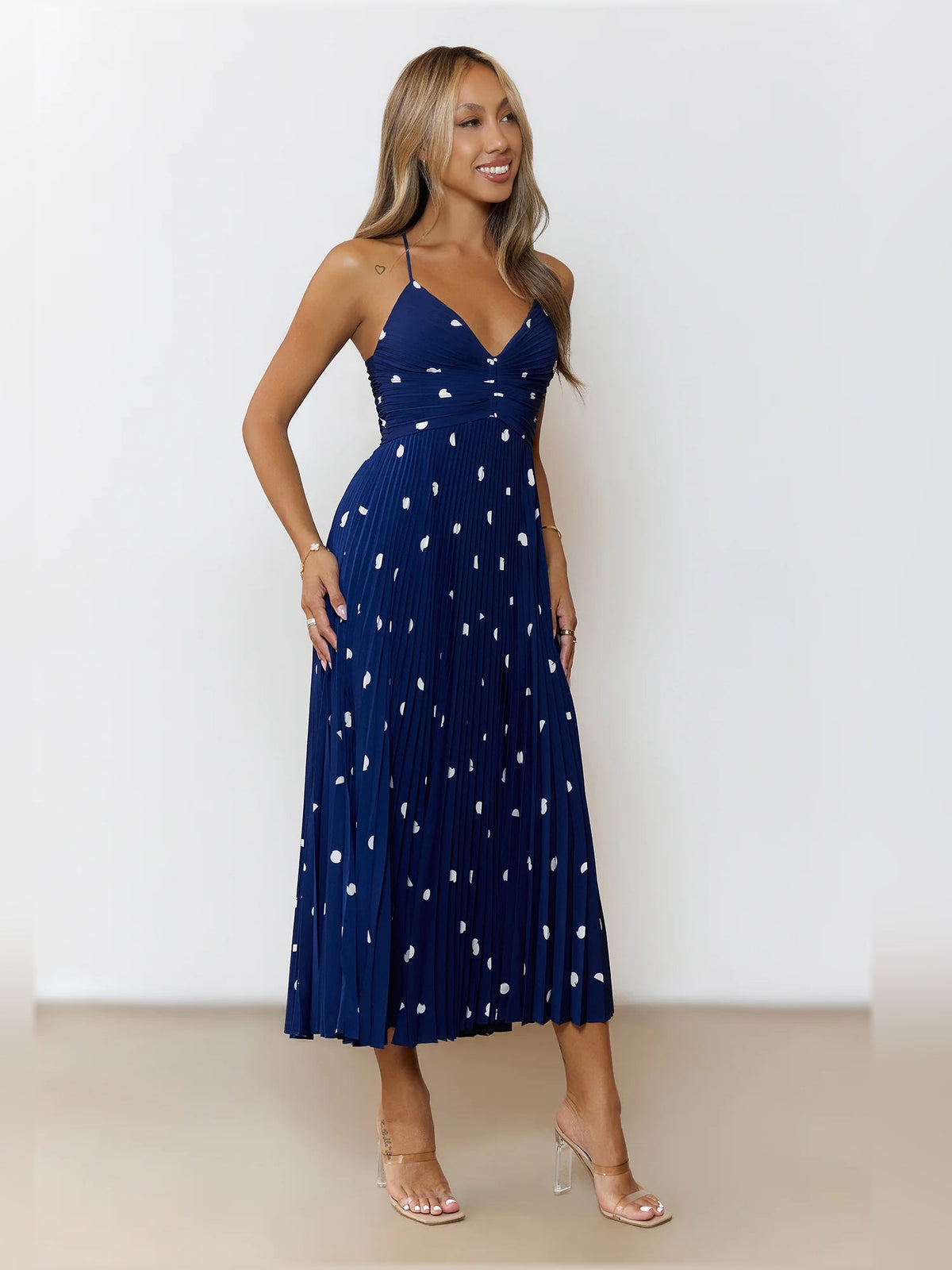 Navy midi formal dress with white dot print, V-neckline and flowing pleated skirt