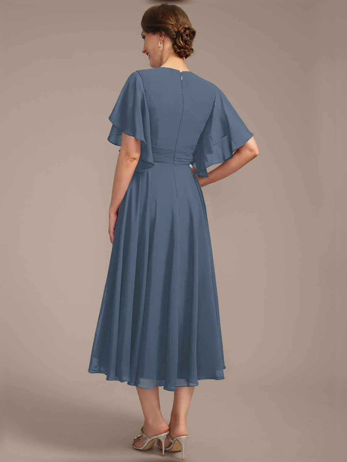 Back view of draped V-neck A-line chiffon dress with pleated skirt and flutter sleeves, blue