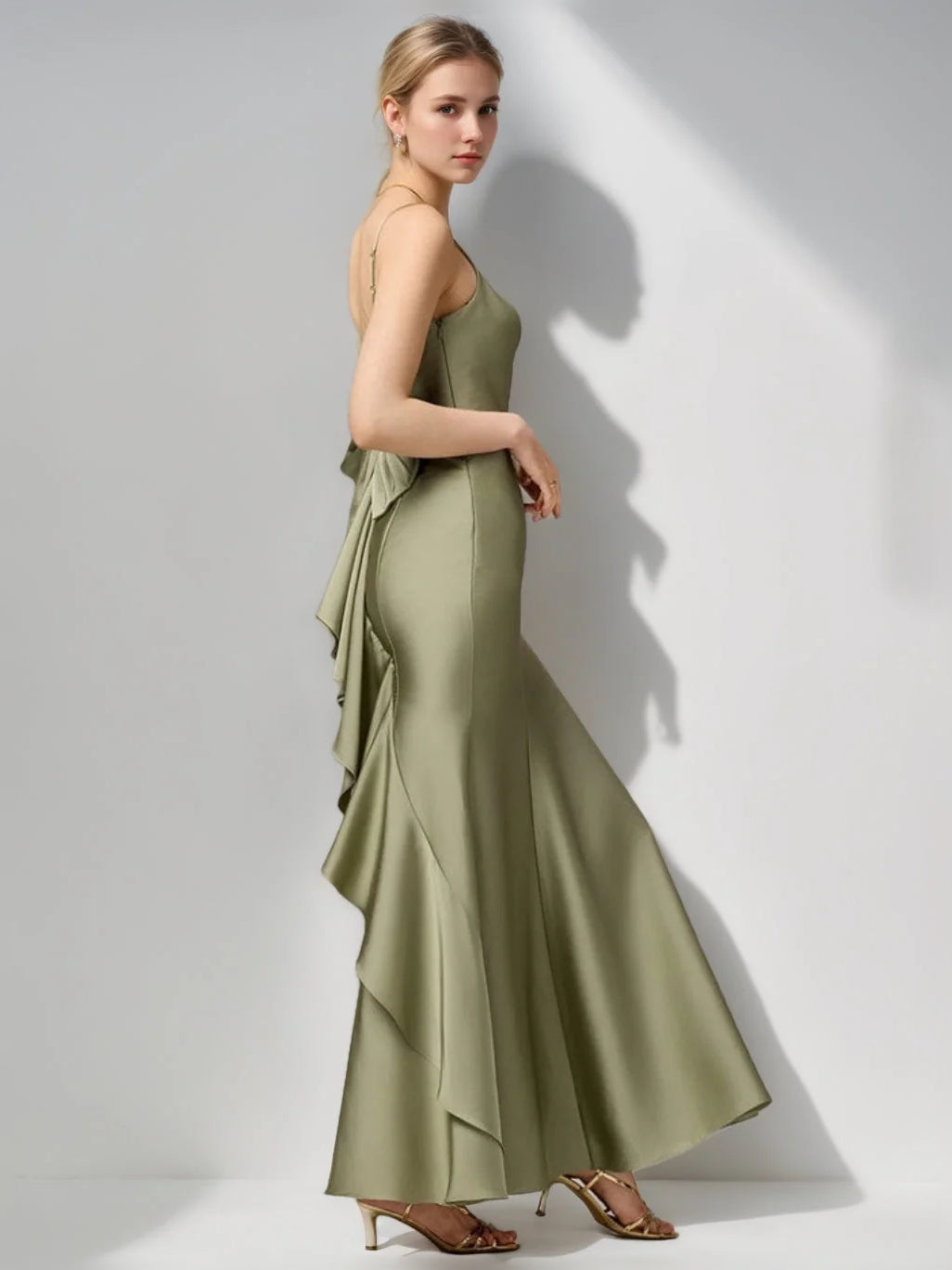 Dusty sage satin sheath dress with sleeveless cut and draped, layered skirt.