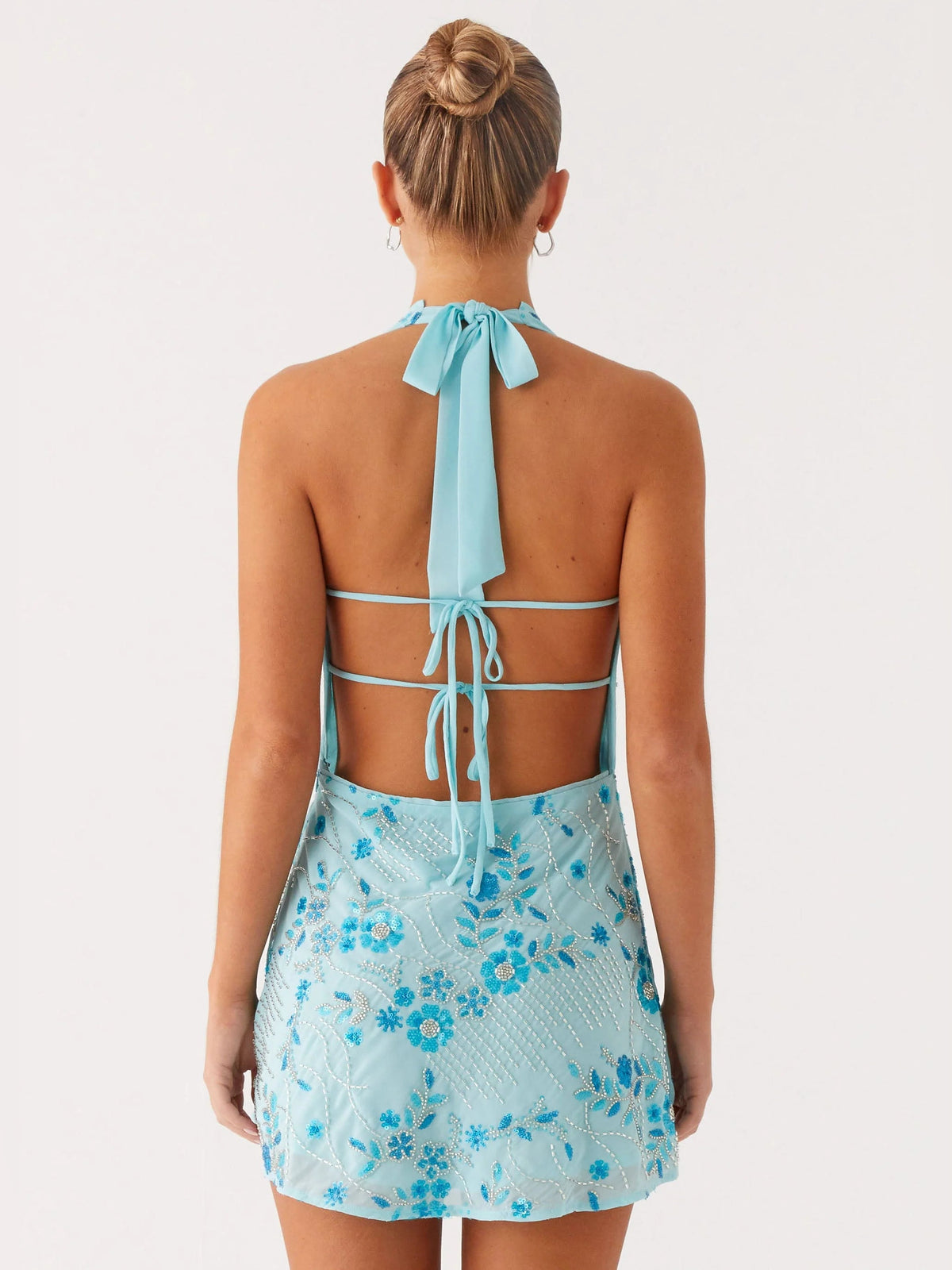 Blue beaded mini homecoming dress from back, crisscross straps with tied neck