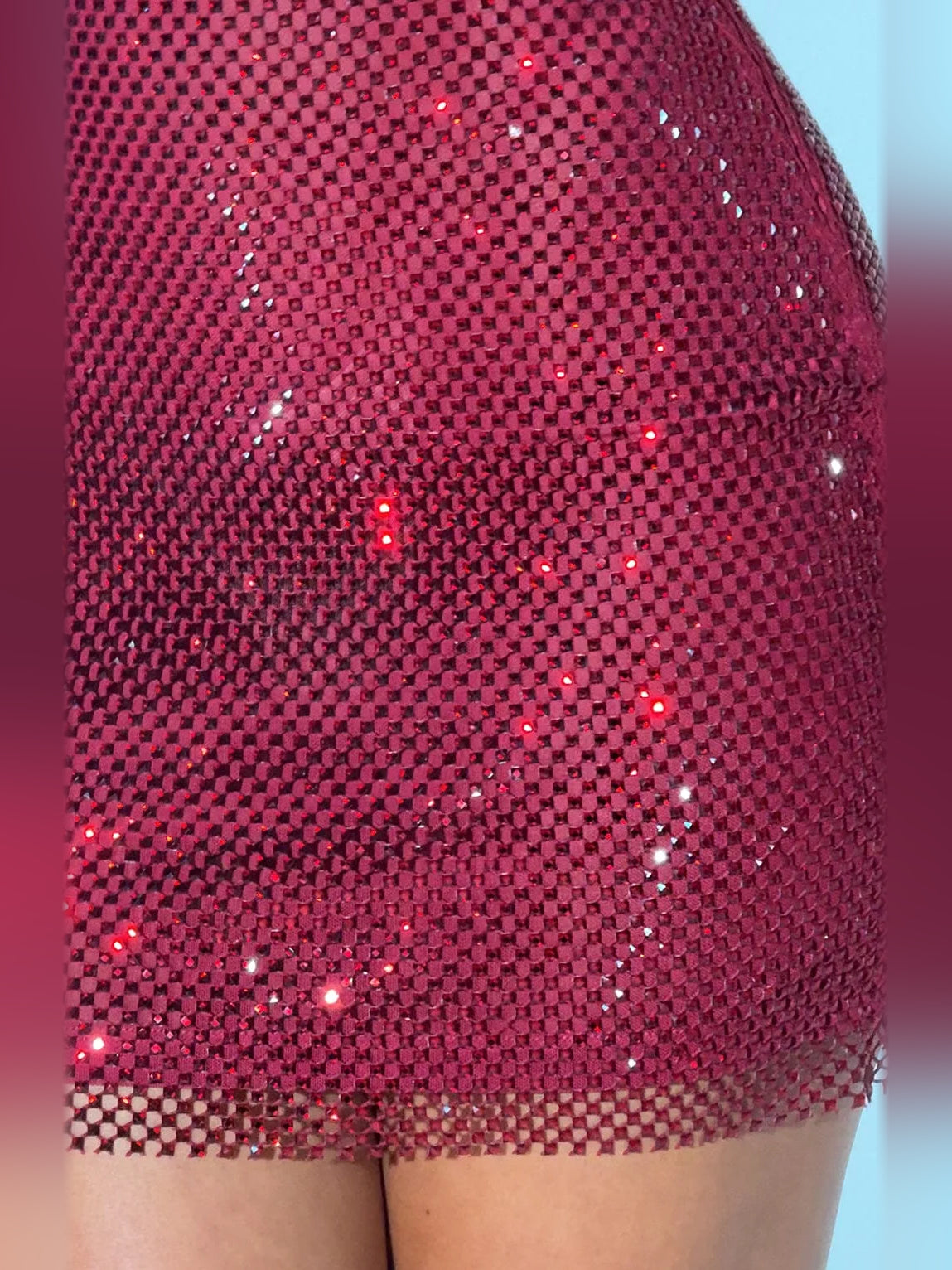 Close-up of wine sequin fabric on mini dress, mesh square pattern