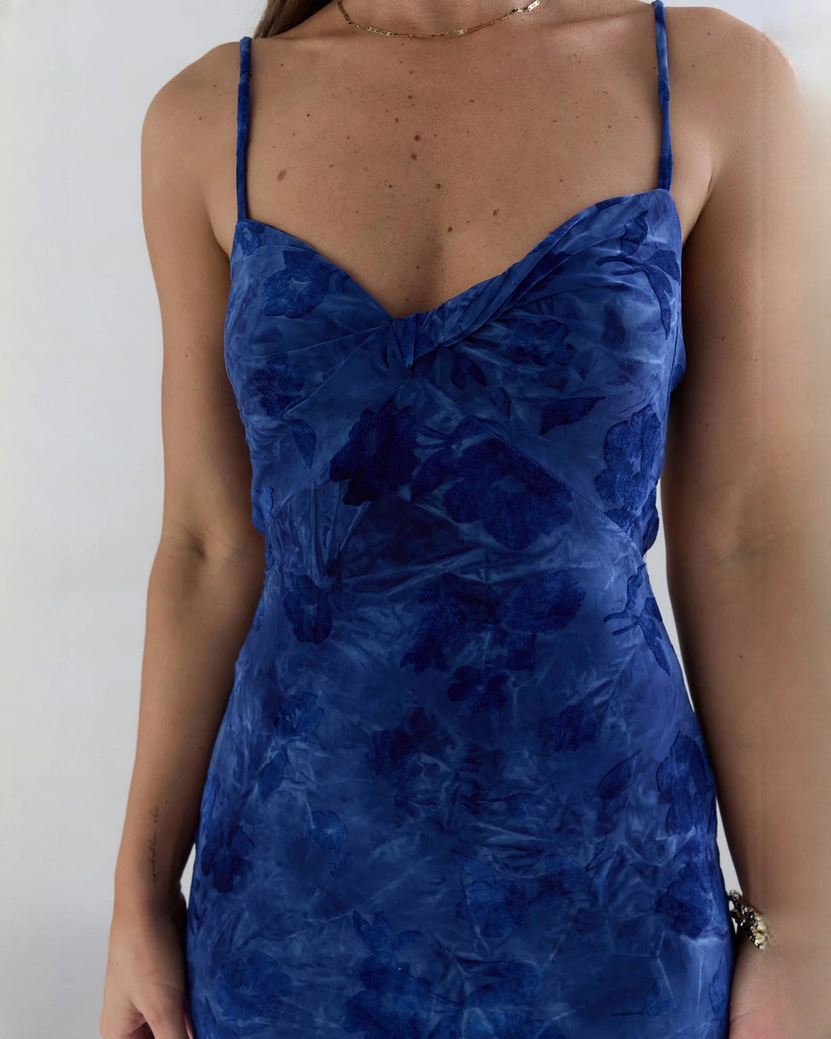 Close-up of navy mesh sweetheart bodice with thin spaghetti straps on a maxi A-line dress.