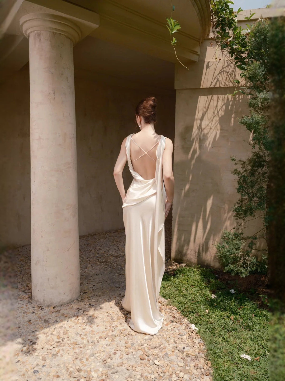 Ivory satin sheath wedding dress with open-back drape and long floor-length skirt