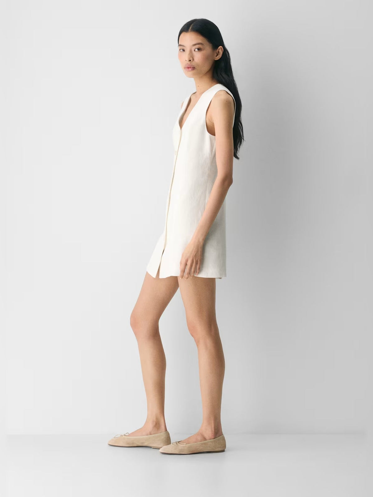 White sleeveless V-neck mini dress, side view showing button front