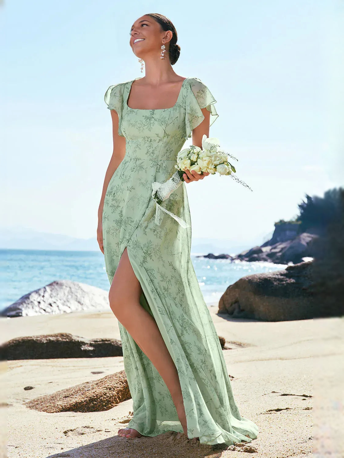 Mint green floral chiffon maxi dress with square neckline and front leg slit, holding bouquet