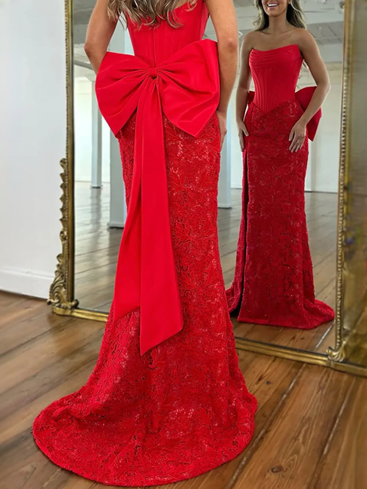 Red strapless mermaid prom dress with large bow on back, lace overlay, and front slit