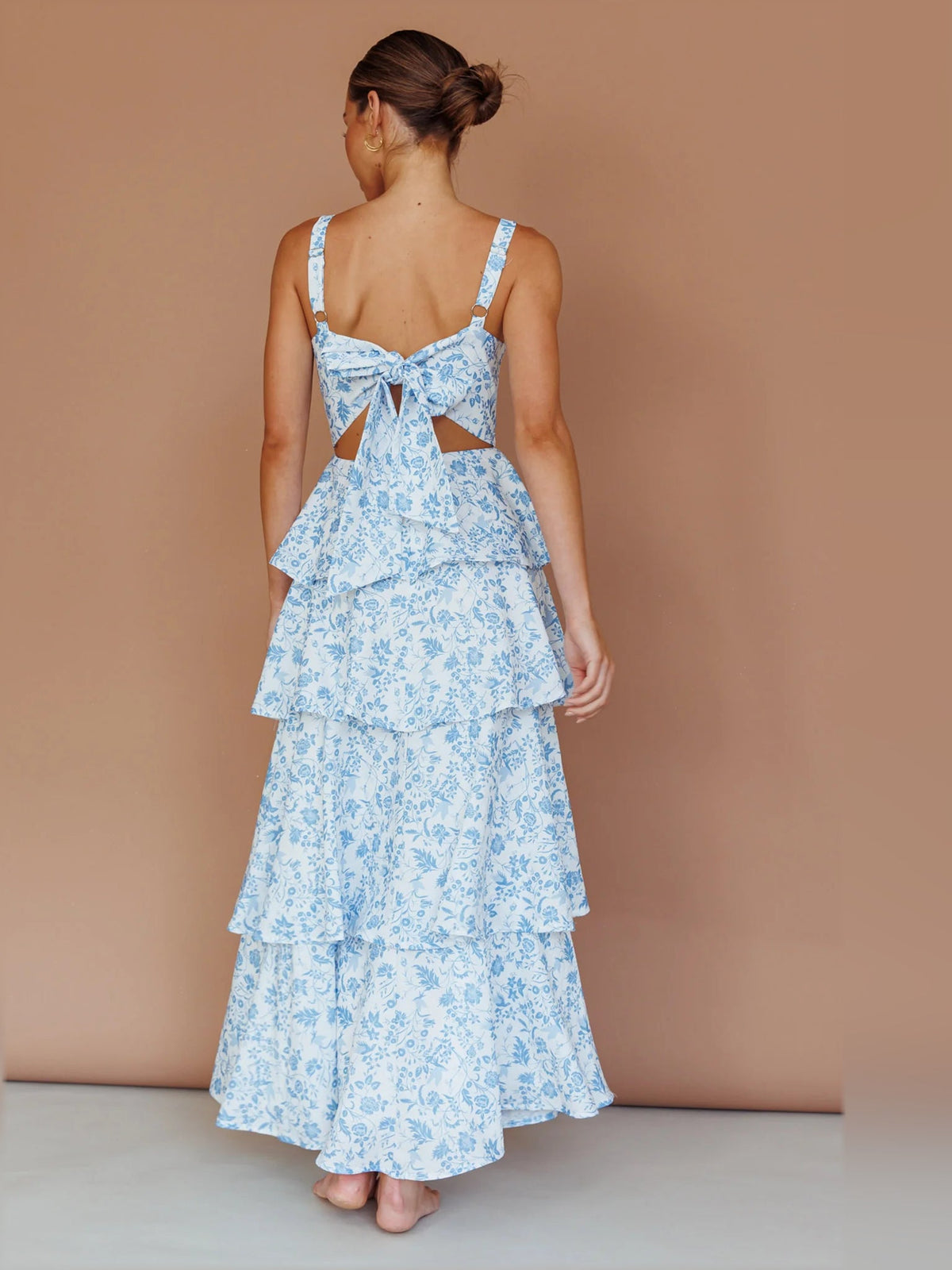 Blue floral tiered midi dress shown from back with bow detail