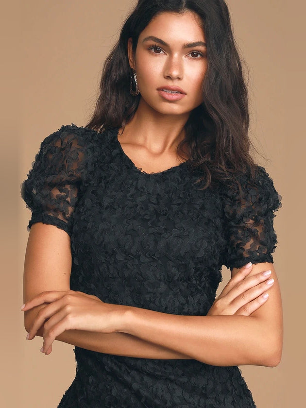 Black textured bodycon mini dress with puff sleeves, close-up of neckline