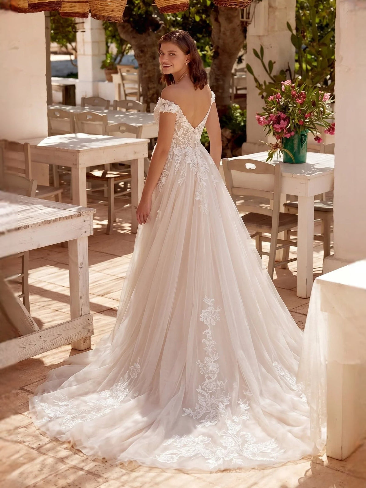 Ivory off-shoulder A-line wedding dress with lace bodice and long tulle skirt, side angle
