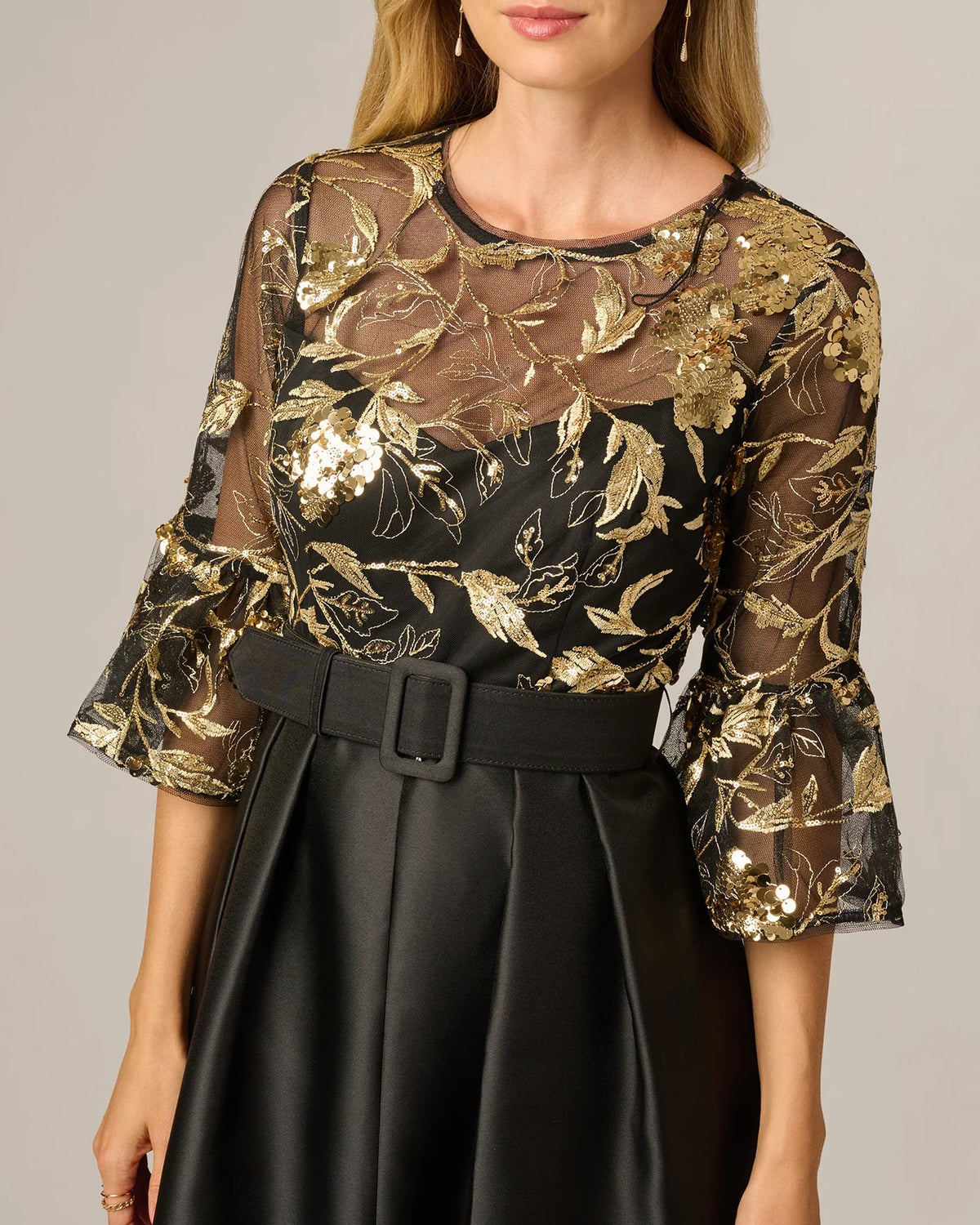 Gold leaf-pattern embellished crewneck bodice over black skirt with waist belt