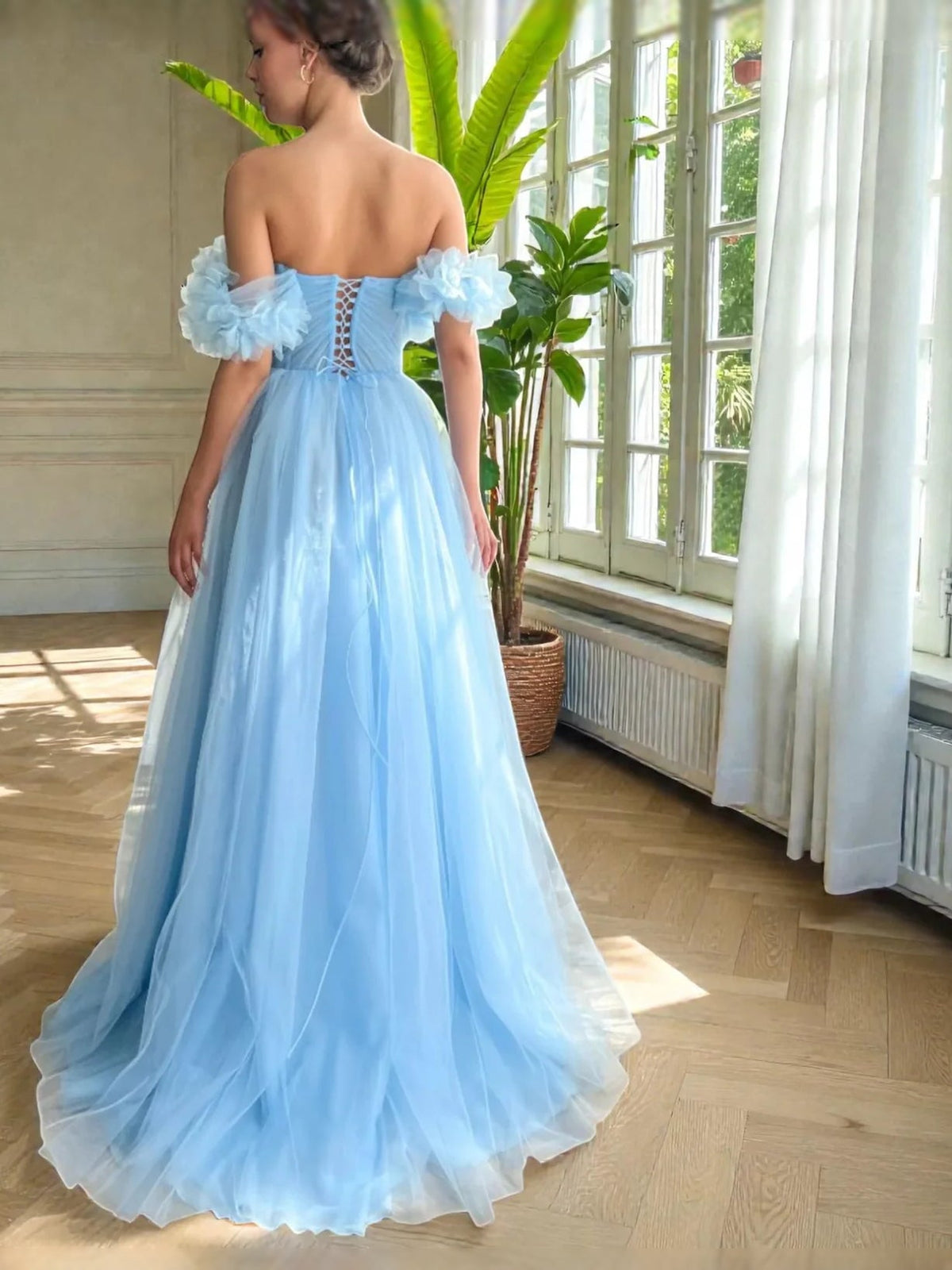 Blue off-shoulder ball gown viewed from back with ruffled sleeves and tulle skirt