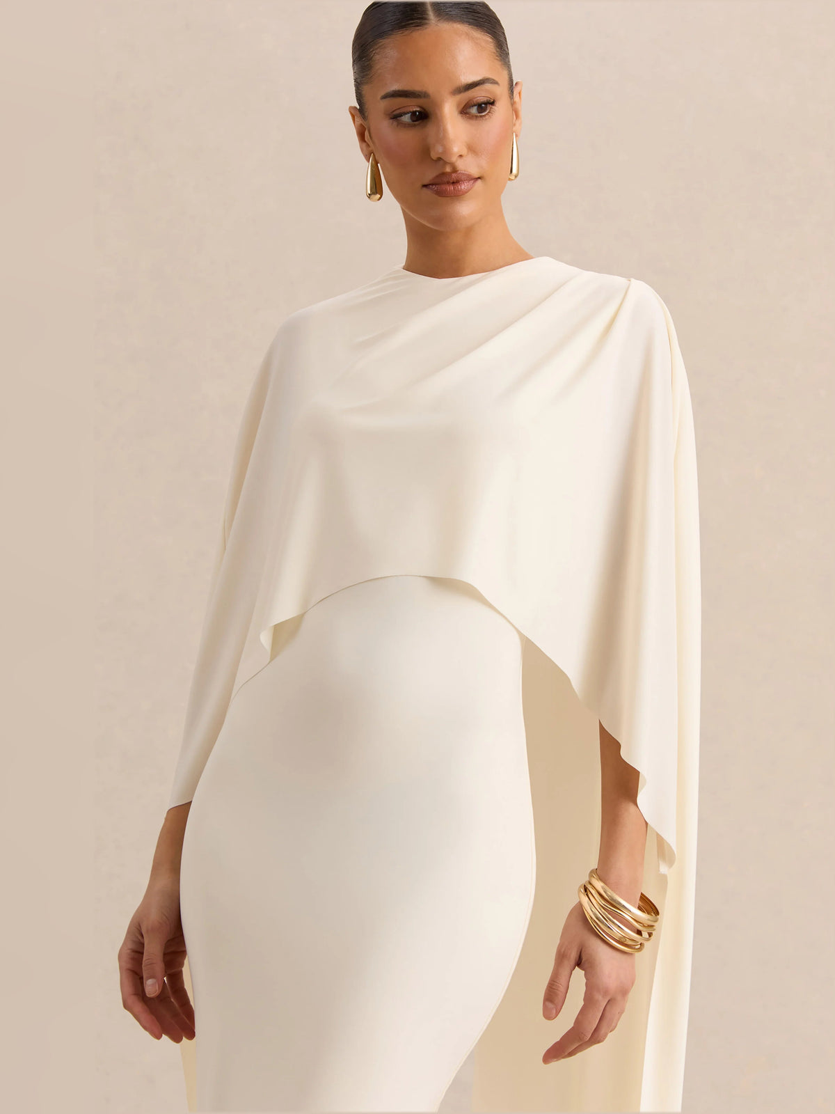 Cream midi dress close-up: draped cape sleeve over round neckline and fitted bodice