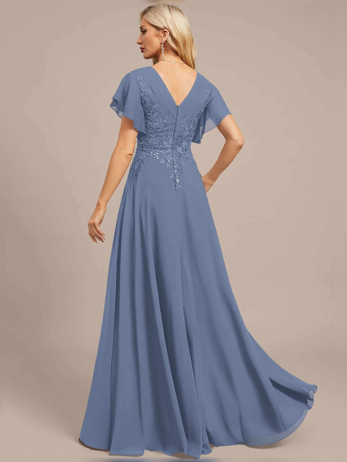 Dusty blue V-neck A-line maxi dress, side view, with floral embroidery and pleated skirt.