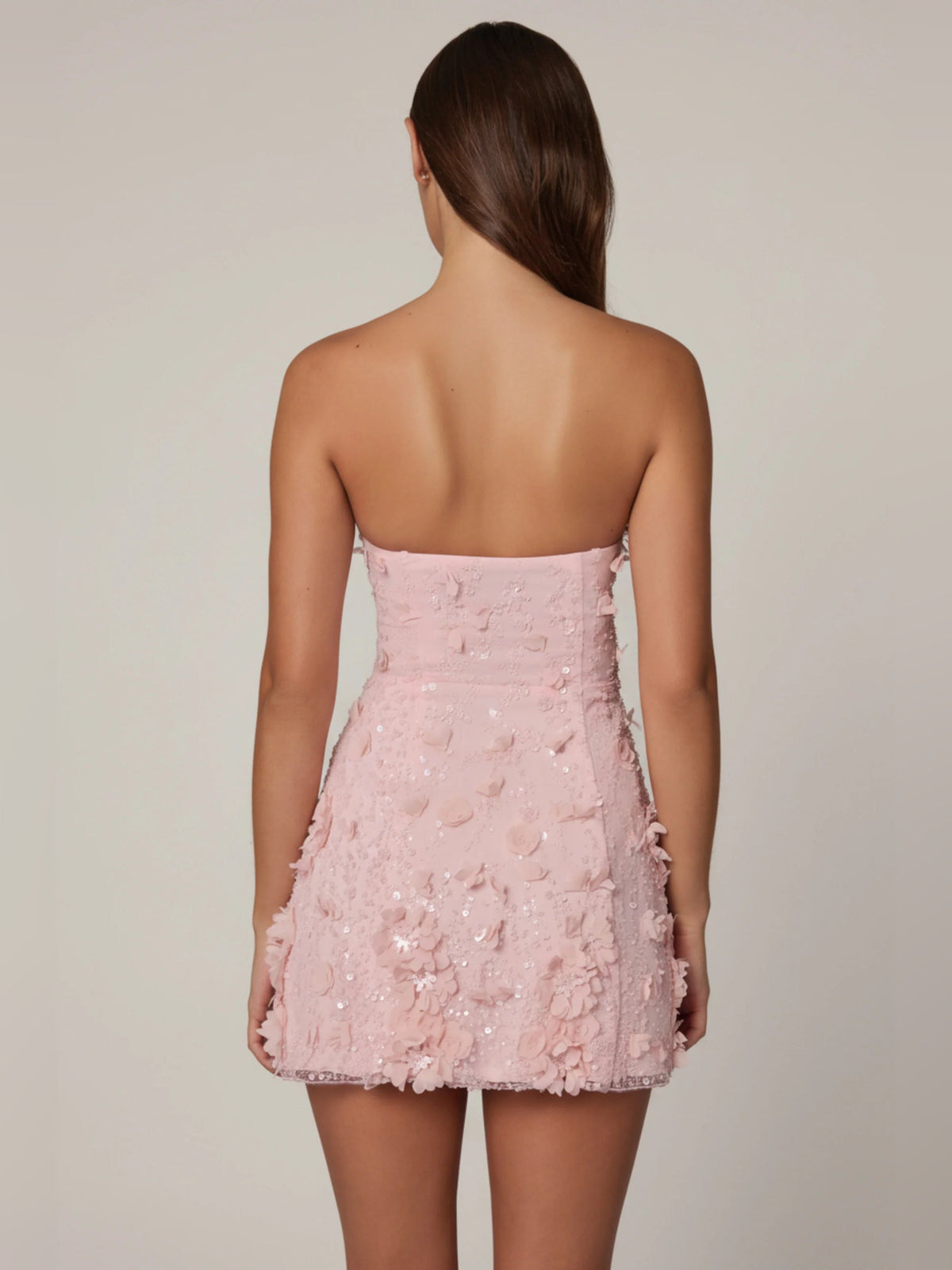 Pink strapless A-line mini dress with textured floral appliqué, back view