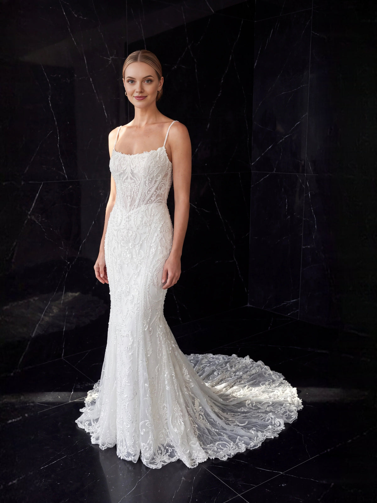 Ivory mermaid wedding dress with lace texture, spaghetti straps, and scalloped tulle hem