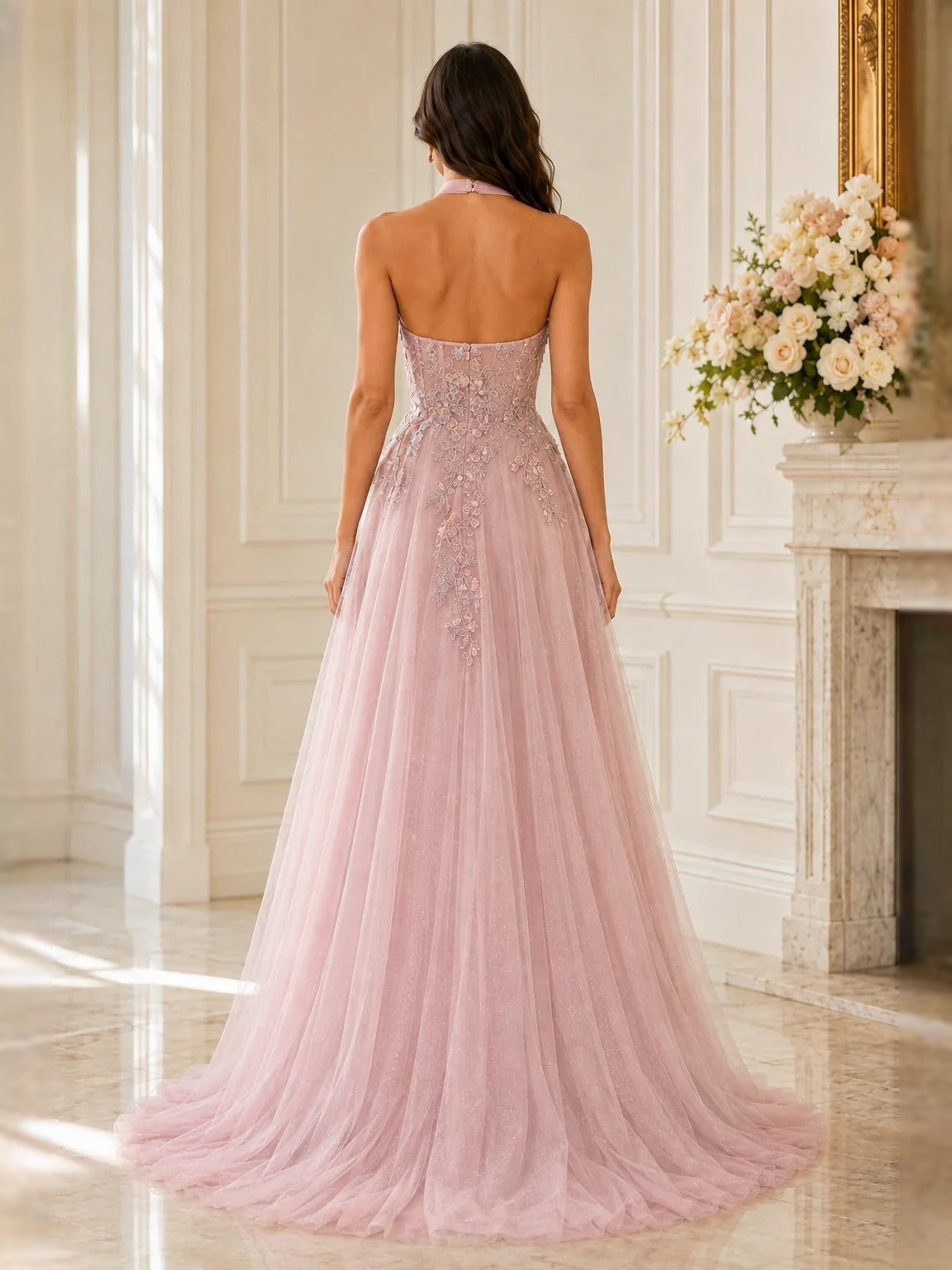 Back view of pink halter tulle prom dress with floral lace bodice and front slit.