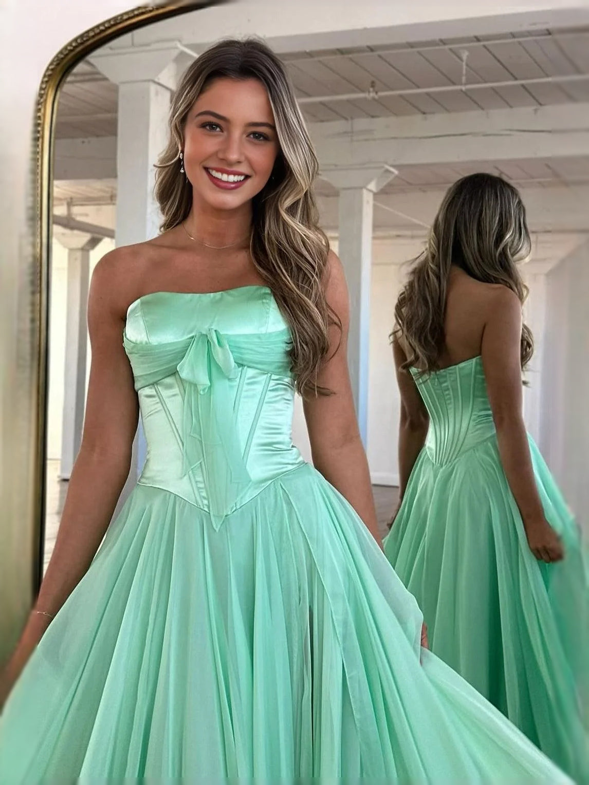 Mint green strapless corset prom dress with central bow and tiered A-line skirt
