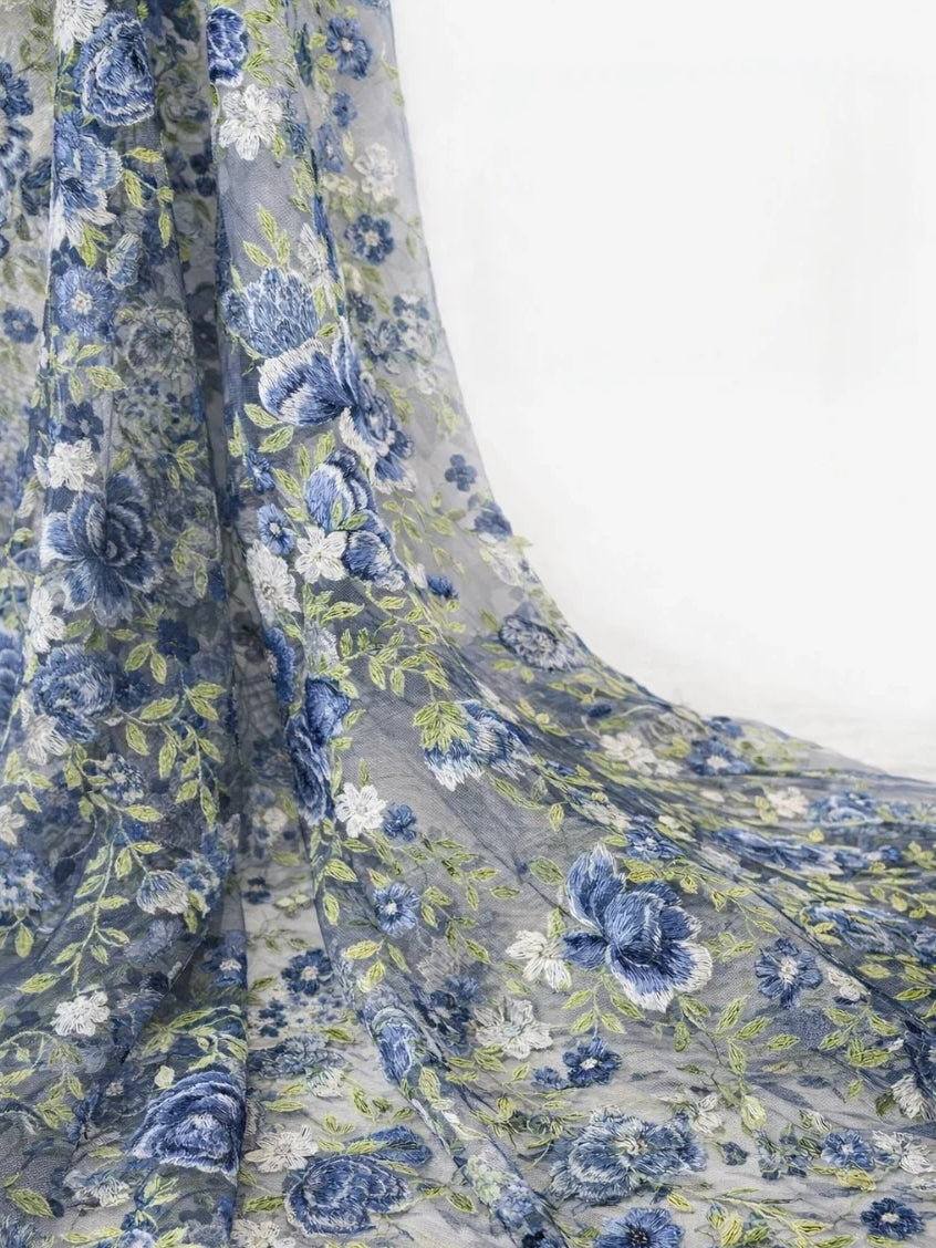 Close-up of blue-and-white floral embroidery on satin fabric