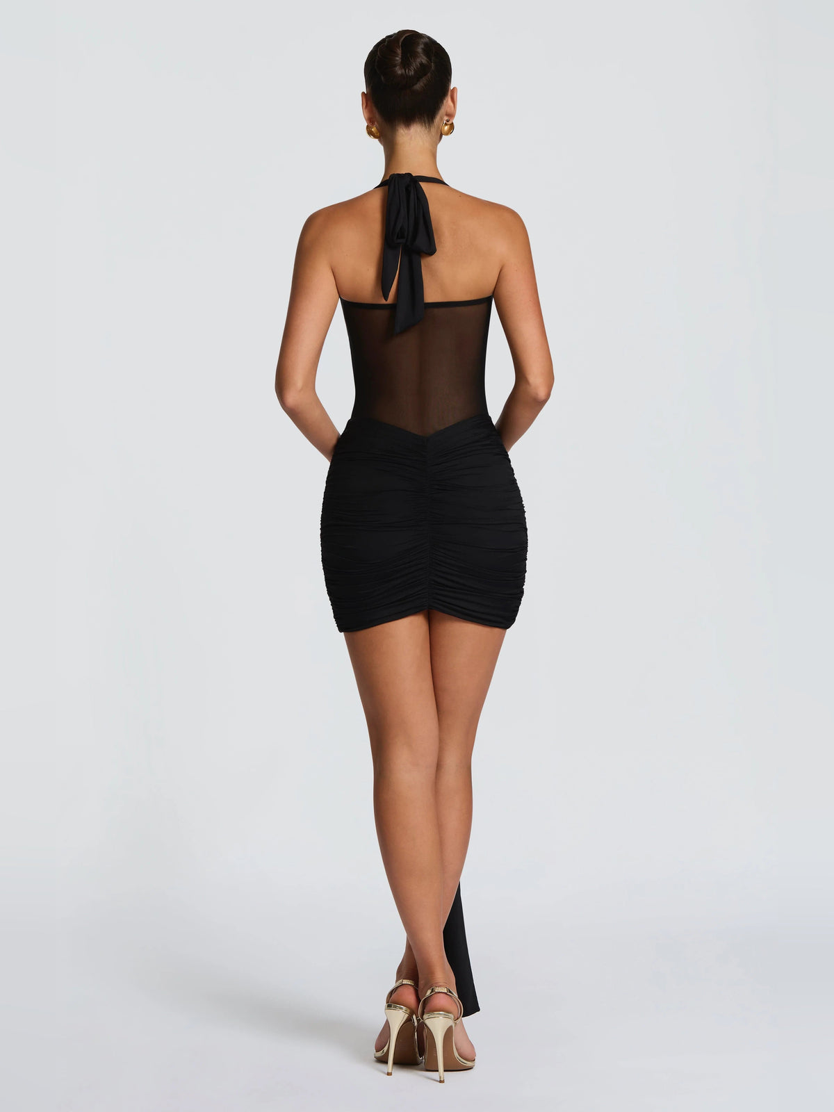 Black halter back mini dress with tie strap, ruched skirt and draped center back