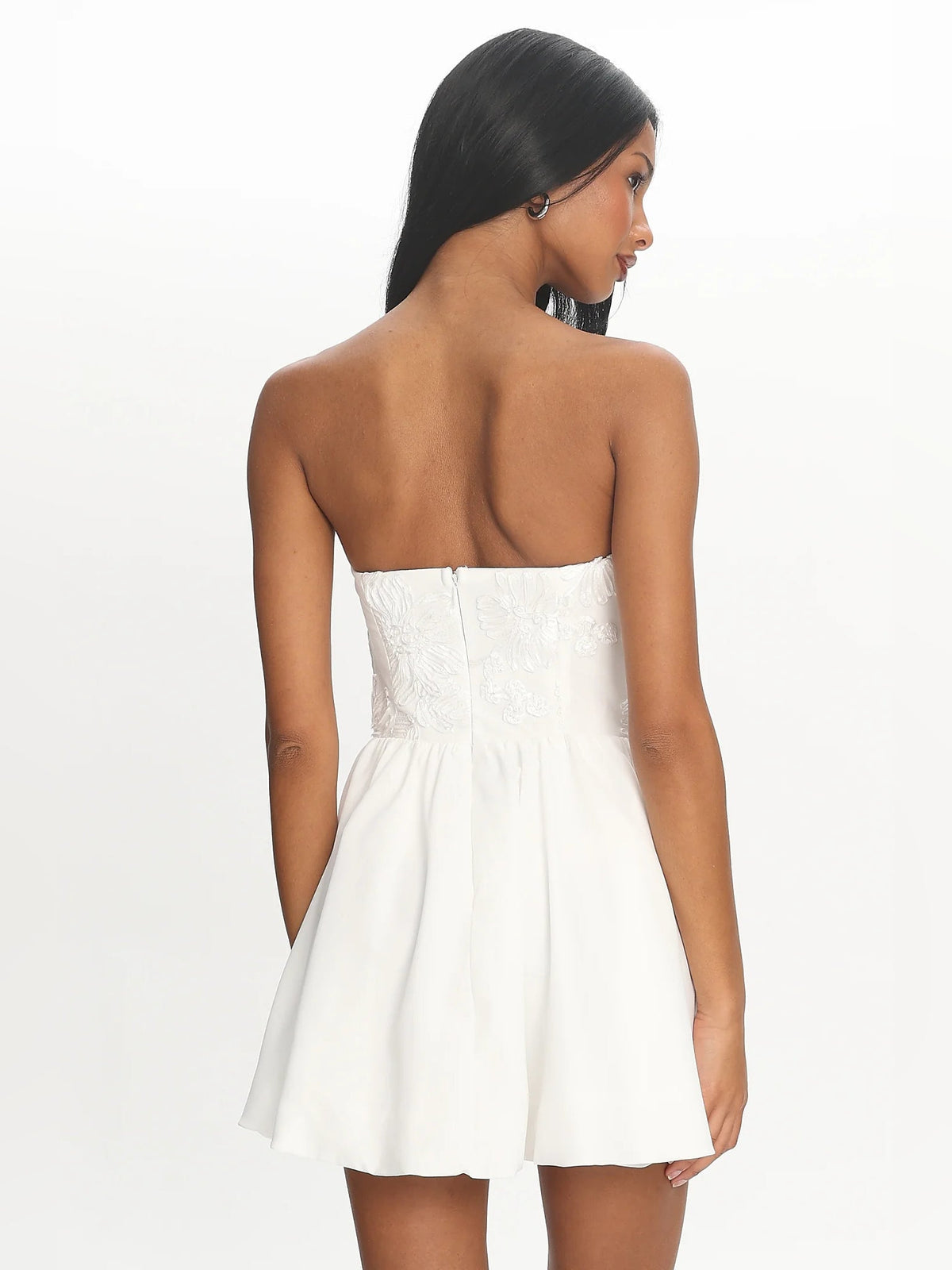 White strapless mini dress, back view, with gathered waist and flared skirt