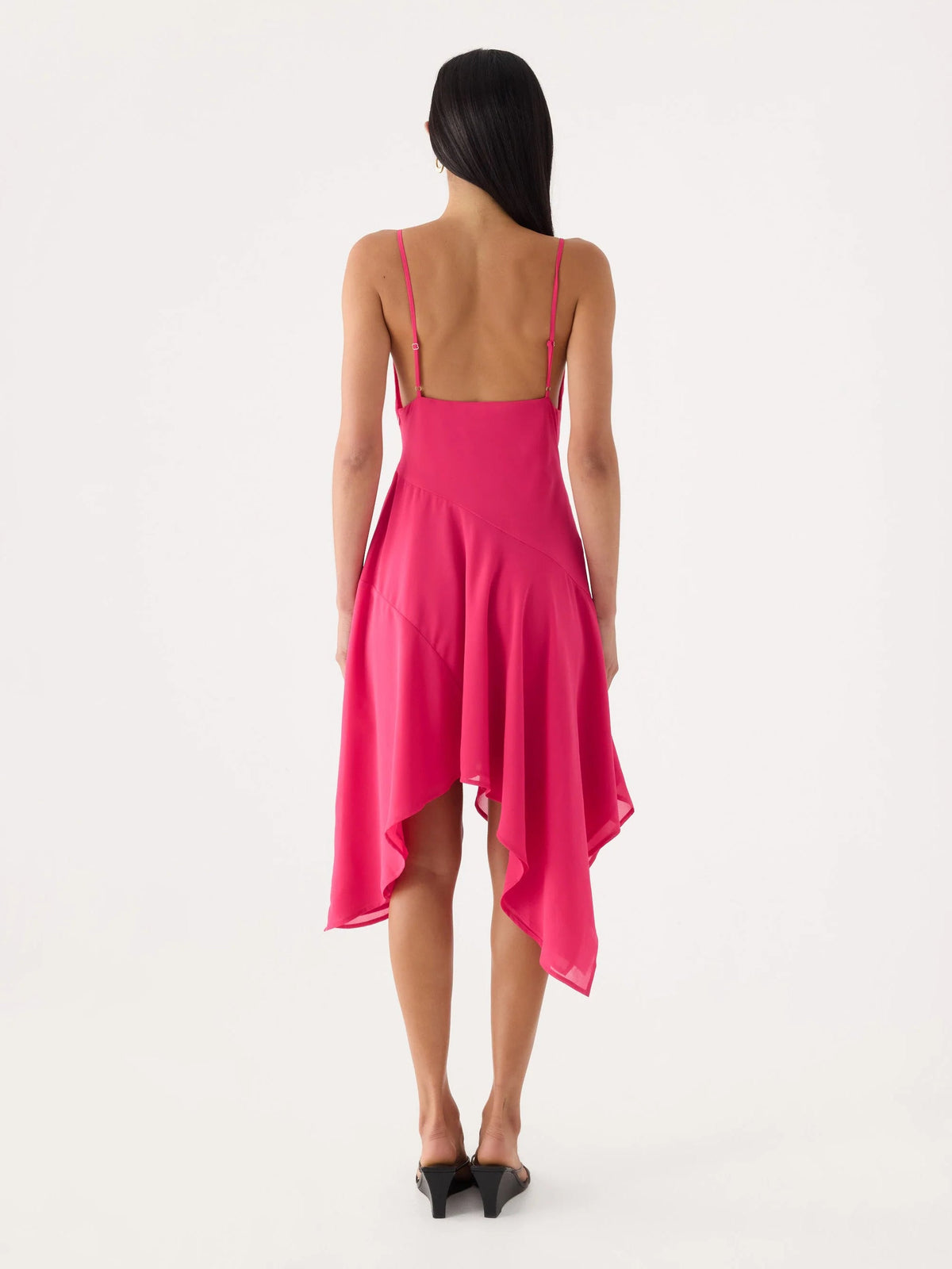Back view of fuchsia midi dress with thin straps and asymmetric draped hem