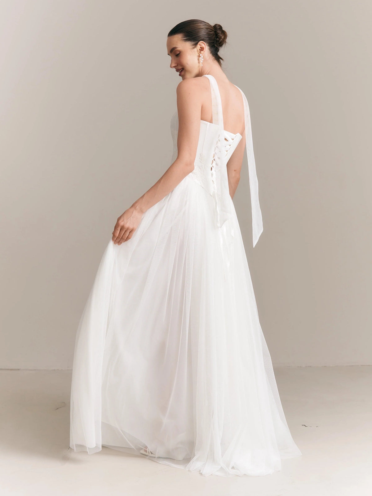 Ivory strapless wedding dress with open lace-up back and flowing A-line tulle skirt
