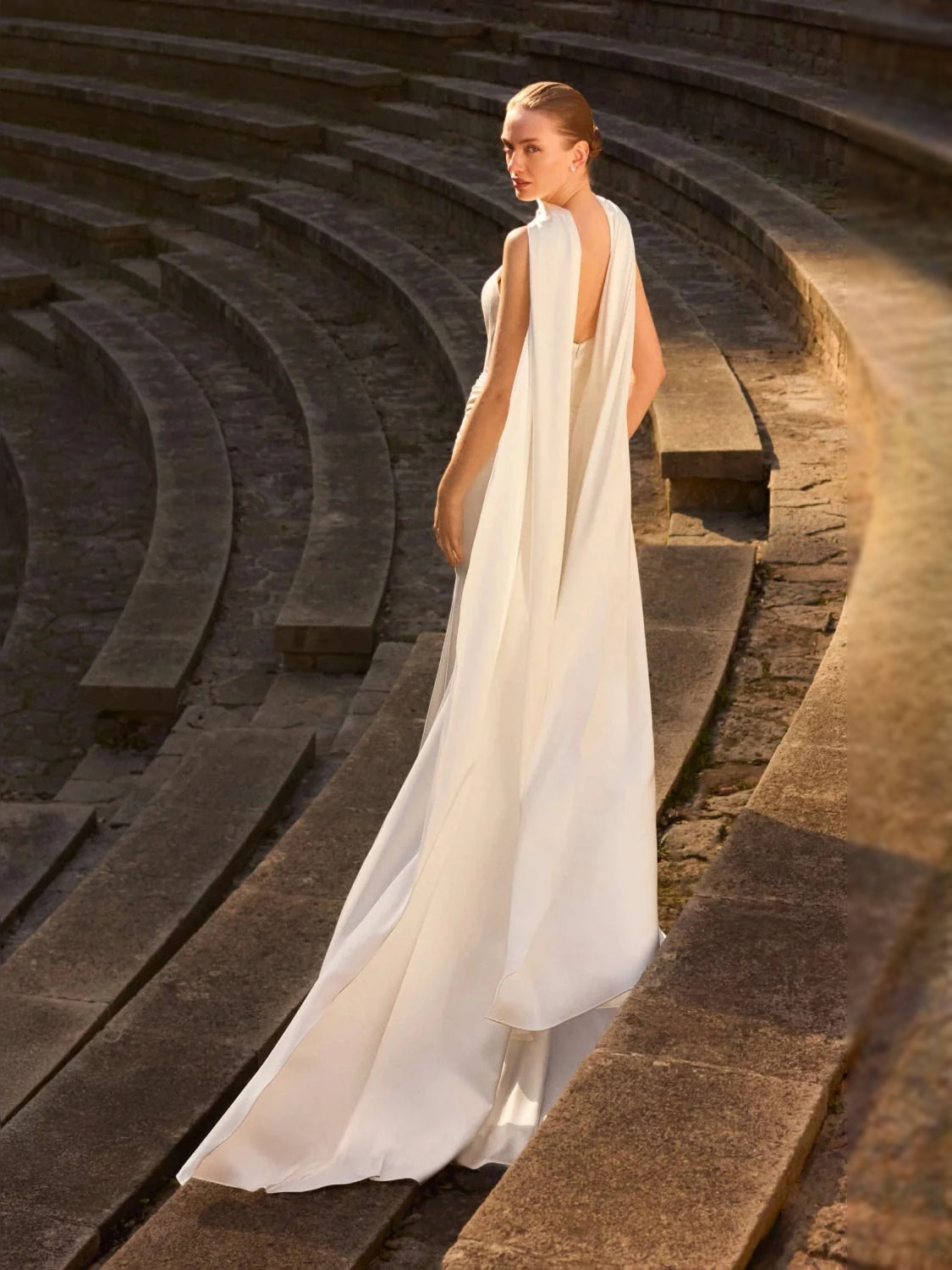 Ivory satin mermaid wedding dress with draped bodice and flowing train, floor-length