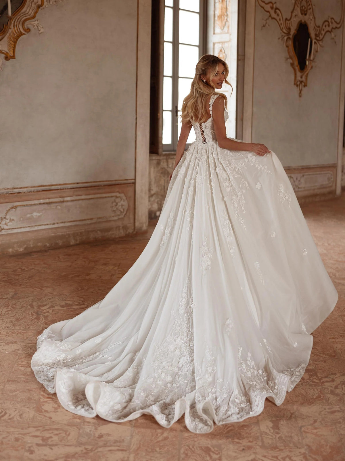 Ivory V-neck ball gown with textured floral lace bodice and sweeping floor-length train