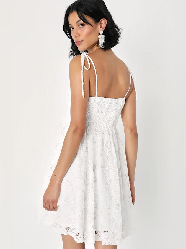 White lace mini dress, back view with adjustable tie straps and A-line skirt.