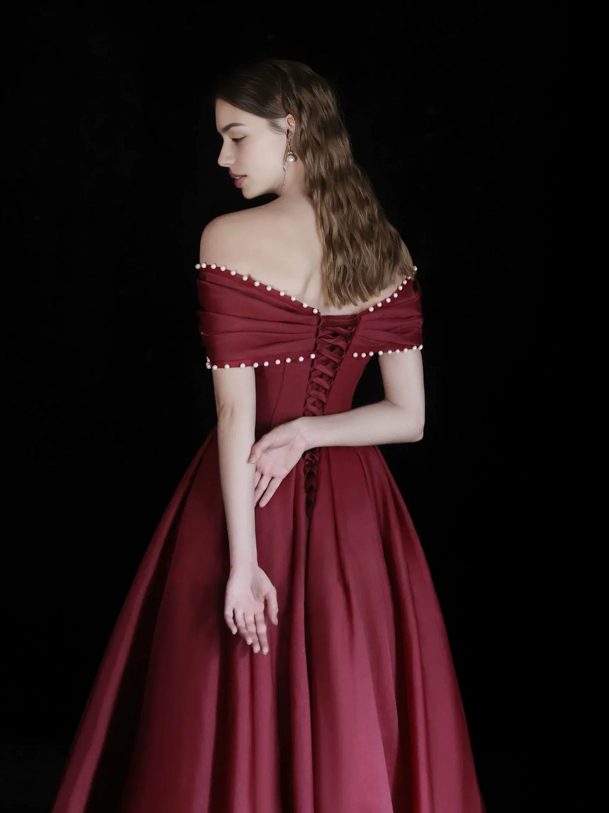 Burgundy off-shoulder corset dress, side view, with beaded shoulder trim and full skirt