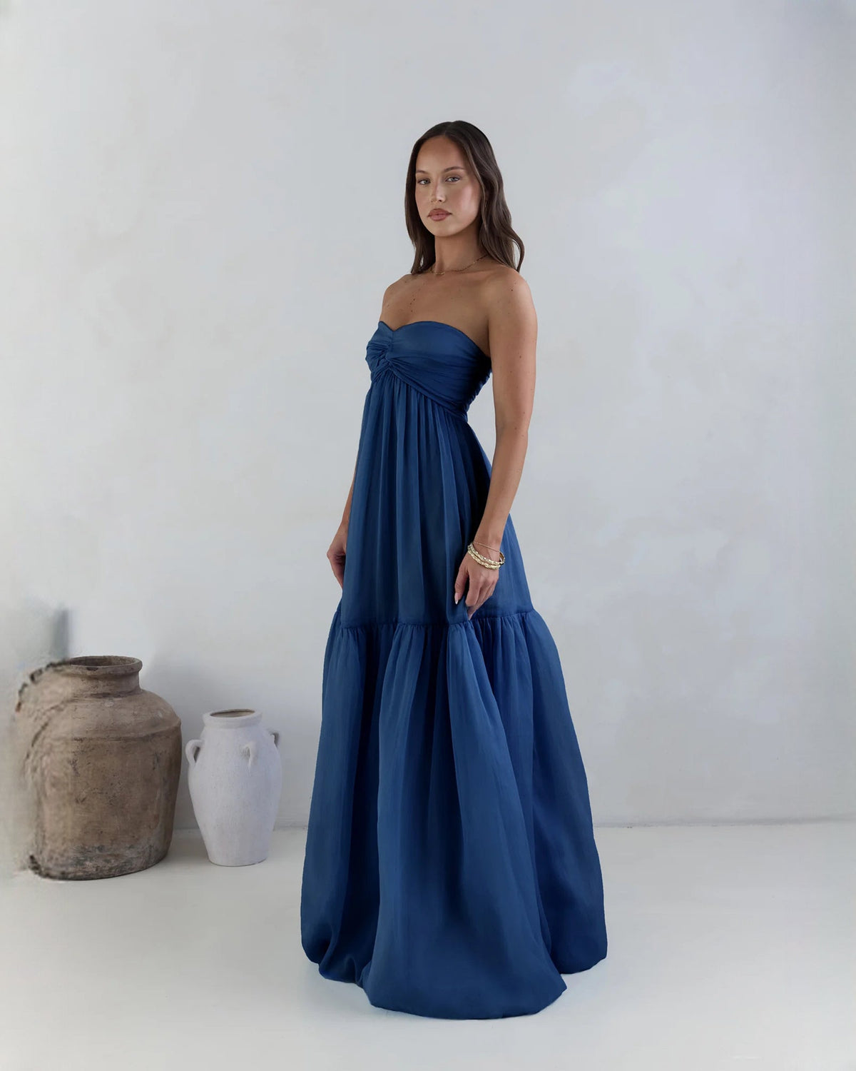 Navy strapless satin A-line maxi dress with tiered skirt and ruched bodice
