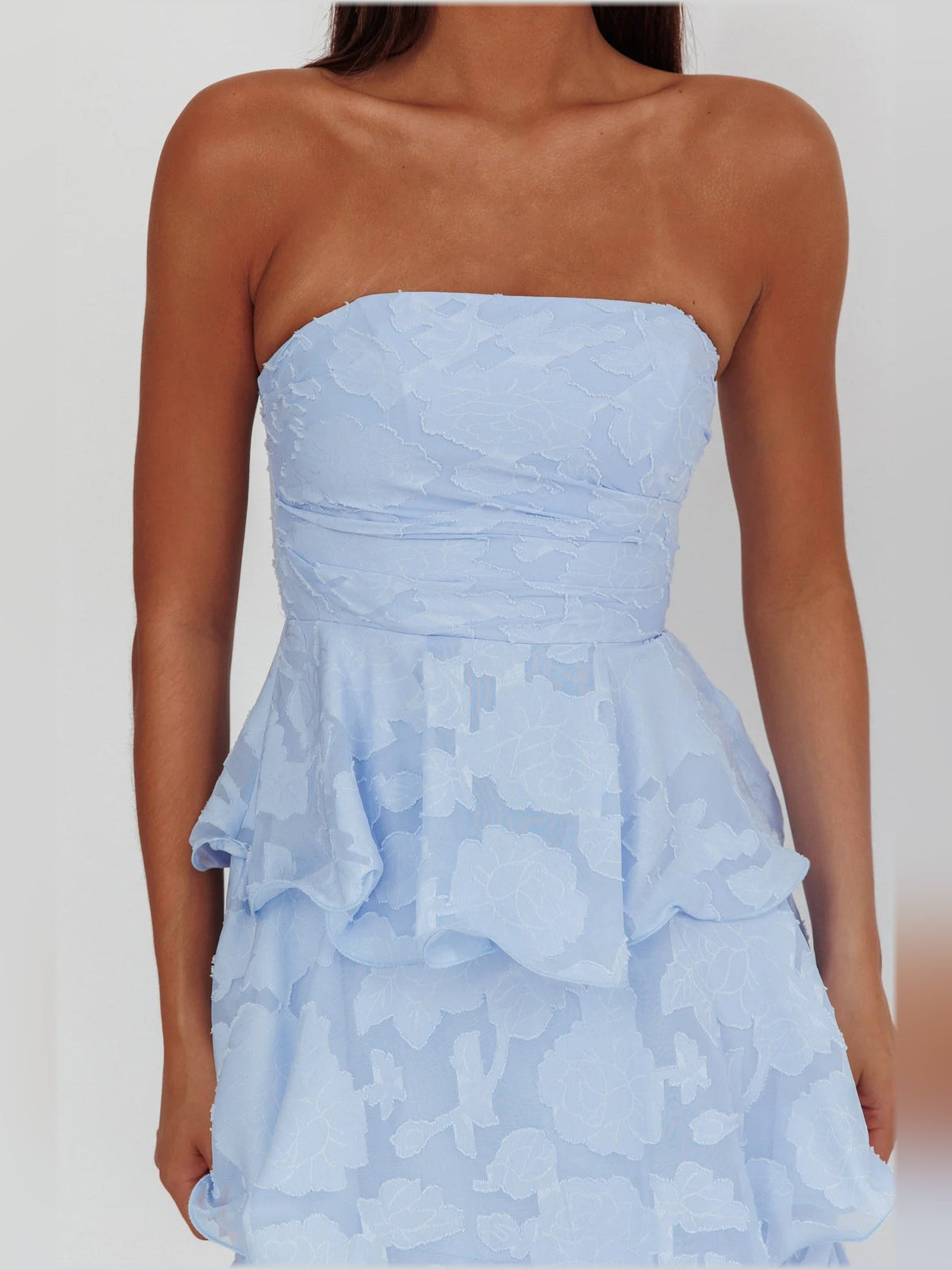 Close-up of blue strapless layered midi formal dress with textured ruffle tiers