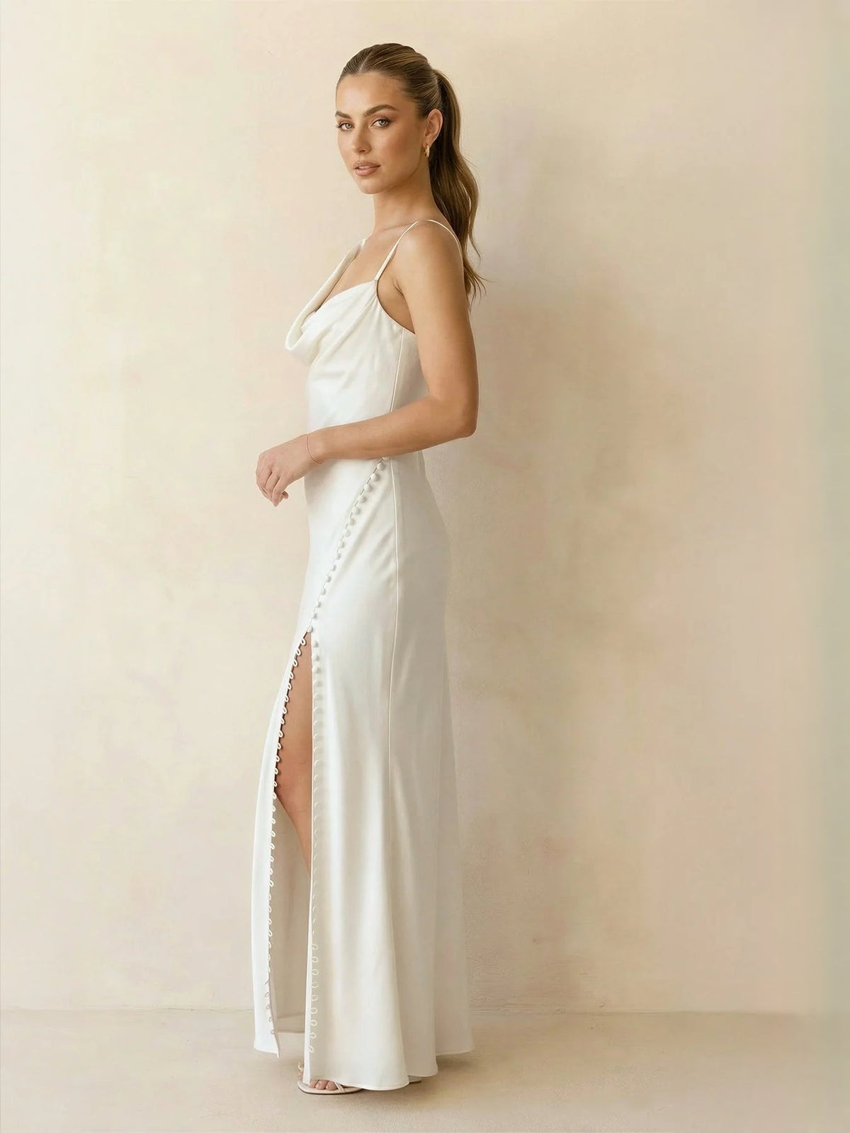 Ivory satin mermaid maxi dress with spaghetti straps, draped waist, and front slit hem