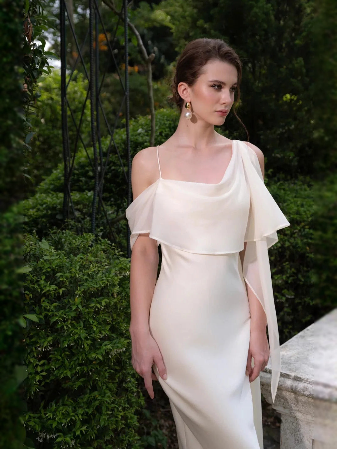 Ivory satin wedding dress with off-shoulder neckline and draped short sleeves