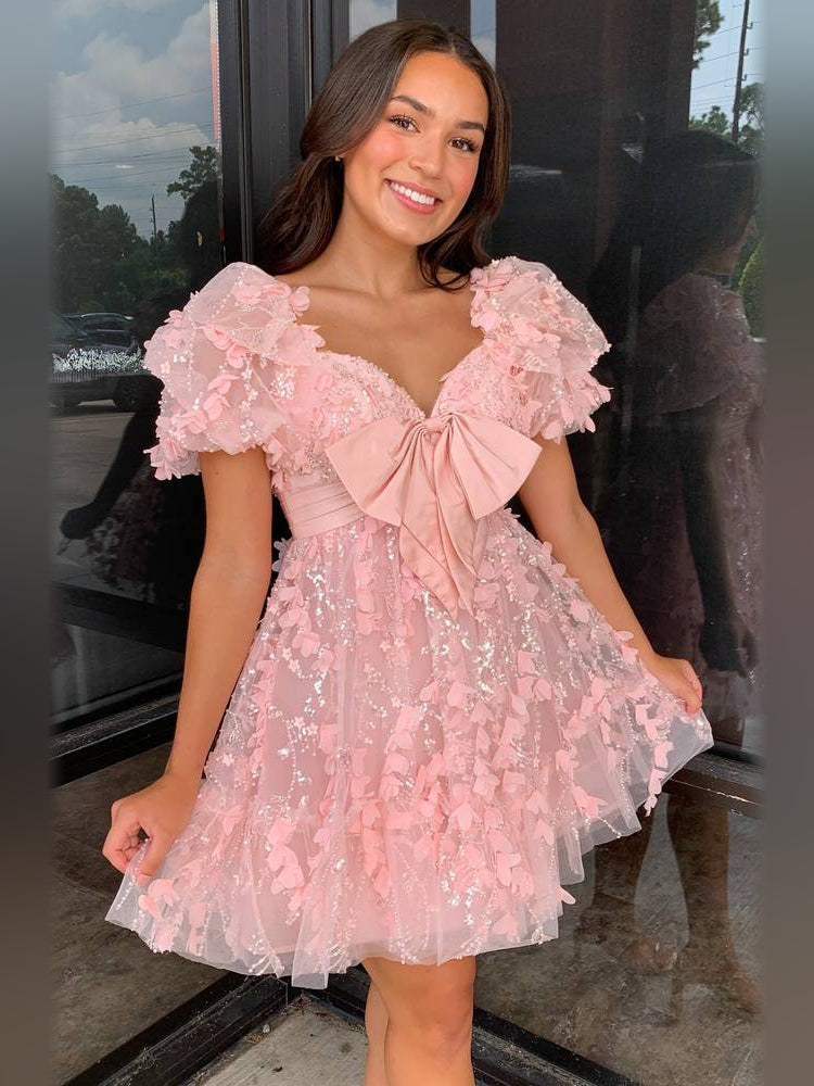 Blush pink short satin dress with sweetheart neckline and large chest bow, ruffled skirt