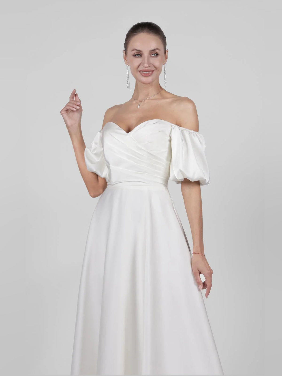 Ivory off-shoulder satin A-line maxi wedding dress with folded, draped puff sleeves